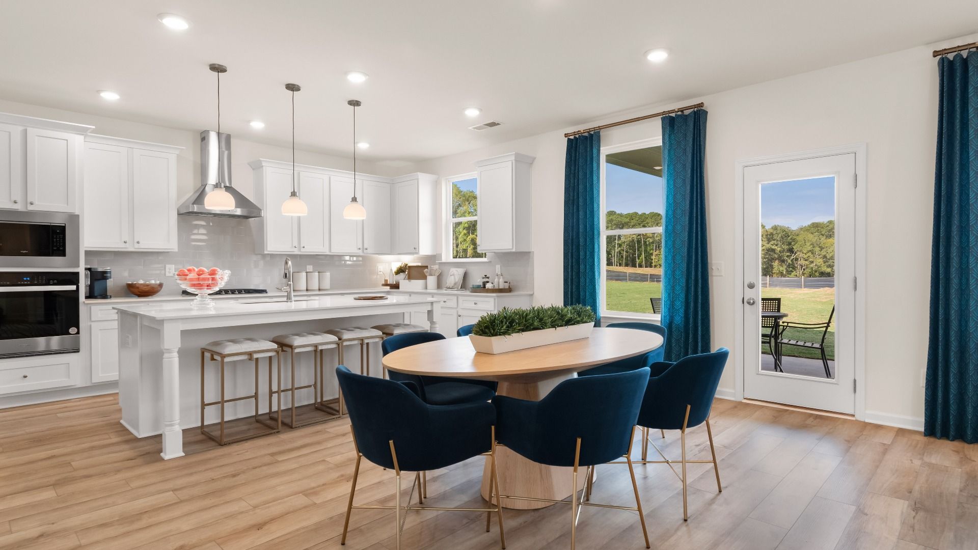 Spacious open breakfast area with view to backyard featuring LVP flooring in the Wagener at Bowers Farm in McDonough, GA.
