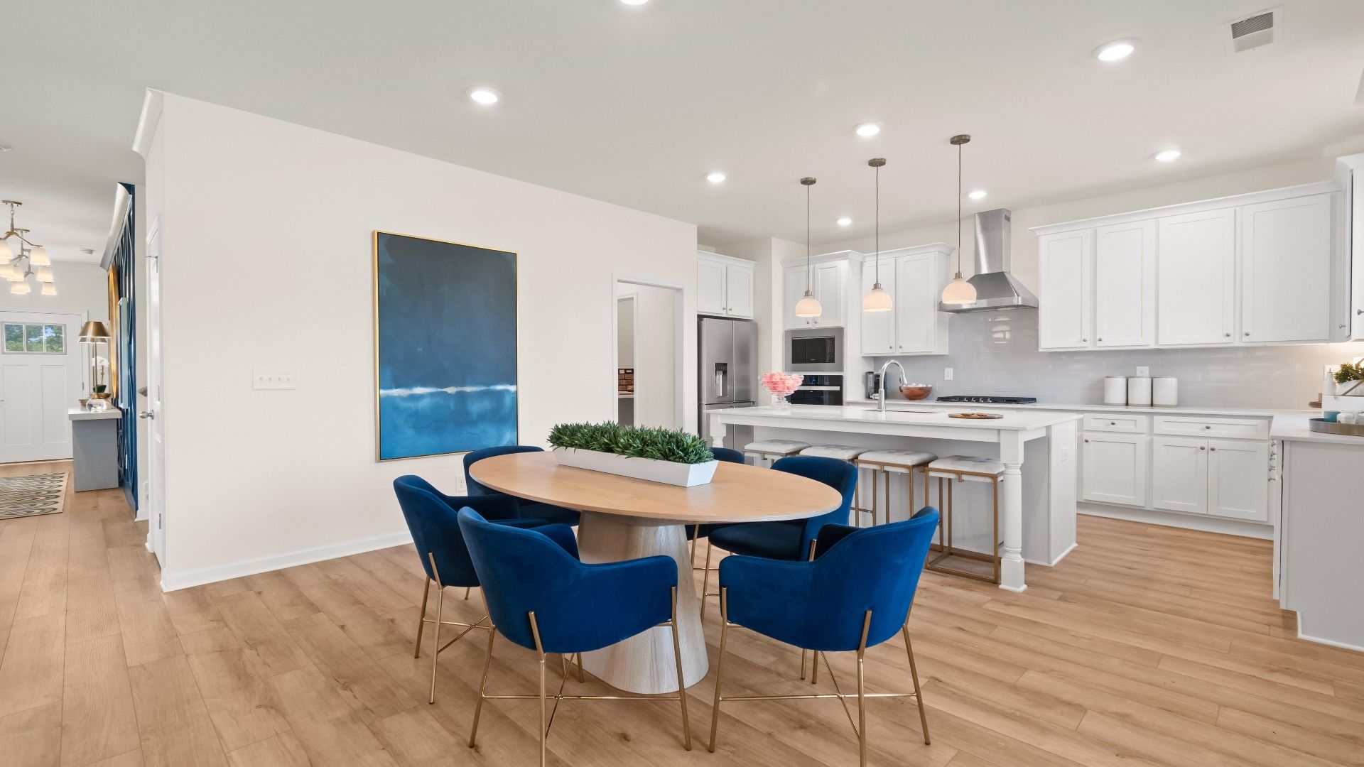 Spacious open breakfast area with LVP flooring and seamless flow to kitchen in the Wagener at Bowers Farm in McDonough, GA.