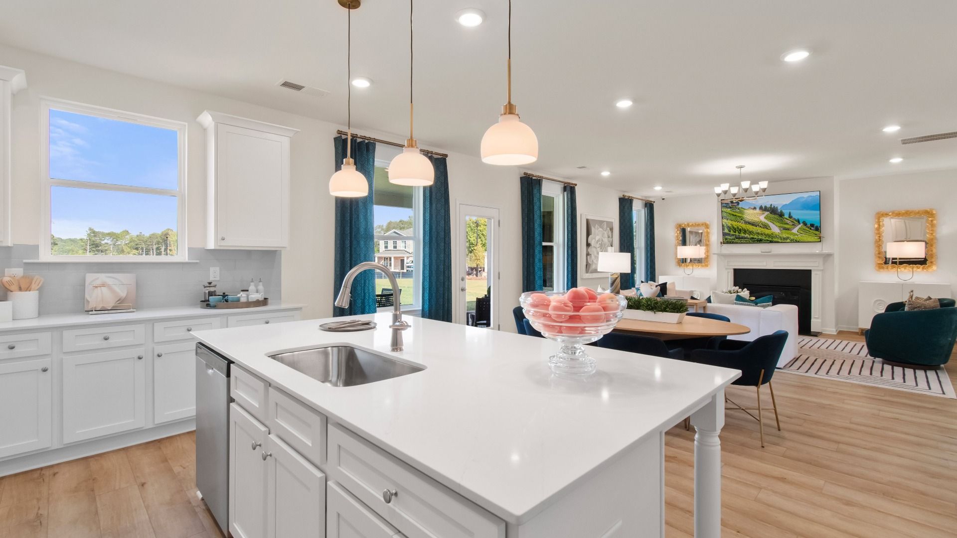 Modern open-concept Wagener kitchen with white cabinetry, natural light, and large island with seating at Bowers Farm.