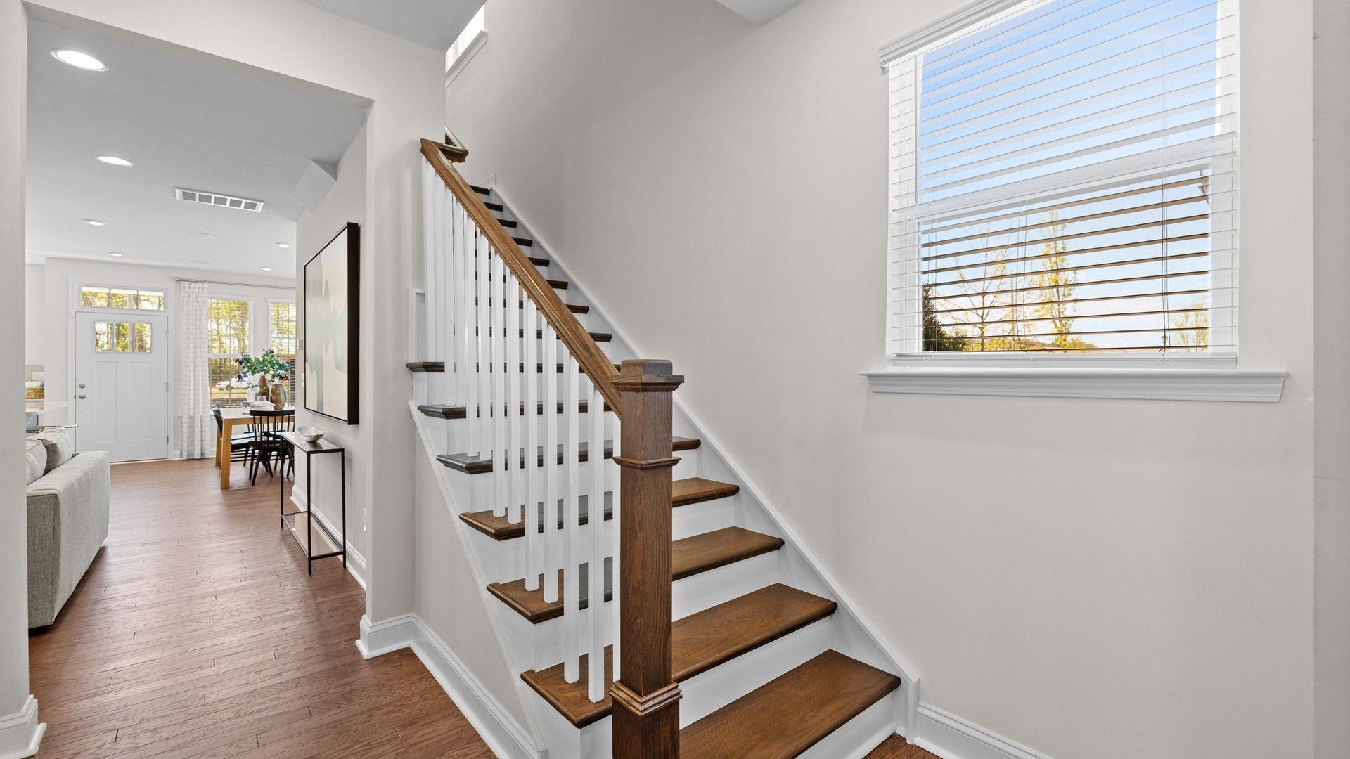 Ample spaces and wide entry solid oak treads stairs with open rails in the Rochester Design by DRB Homes Charlotte, NC