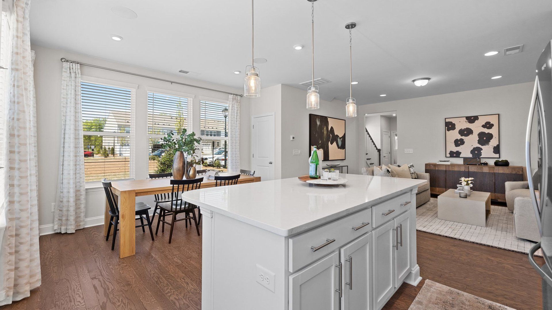 Large kitchen island with quartz top, breakfast area, and family room in the Rochester Design by DRB Homes Charlotte, NC