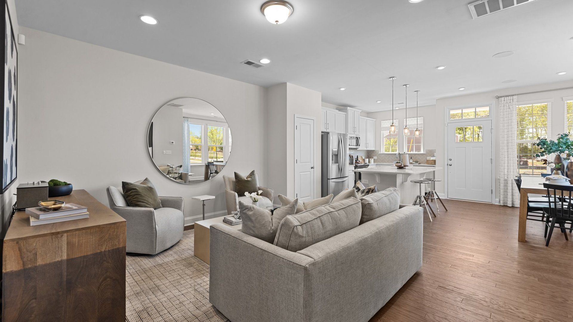 Rochester open-concept family room, kitchen with island, and bright dining area with large windows. DRB Homes. Charlotte, NC.