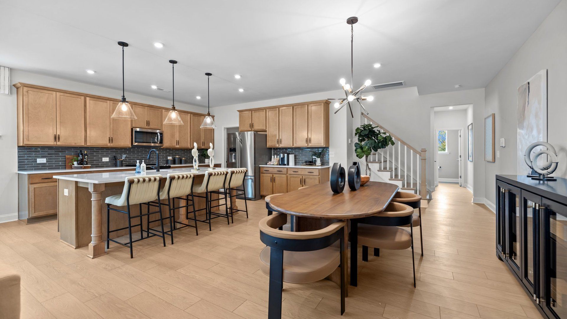 Open-Concept dining area and kitchen with premium lighting in the Adaline Plan new townhome by DRB Homes Charlotte