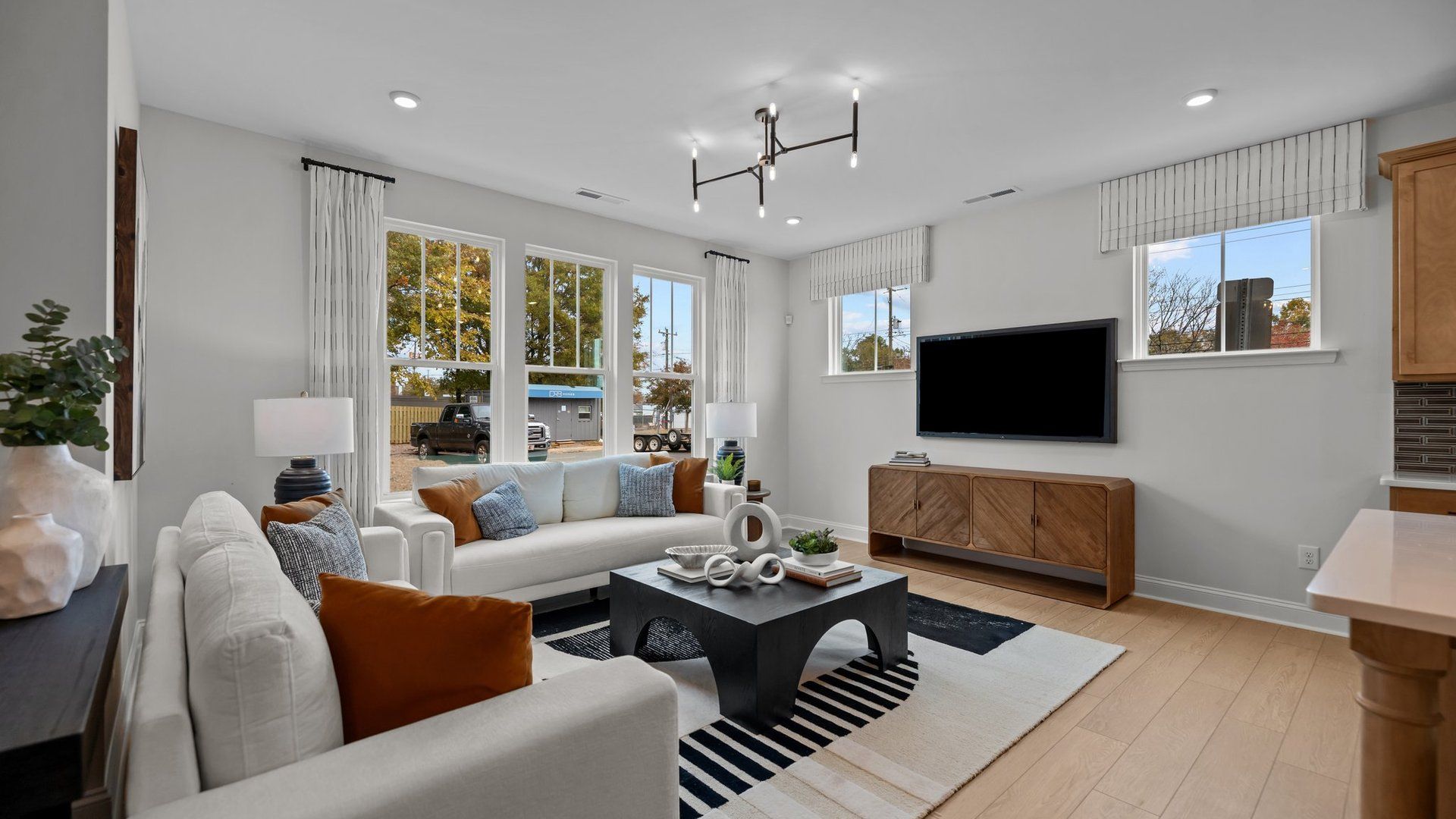Family room with premium lighting and large windows in the Adaline Design new townhome in Charlotte, NC by DRB Homes