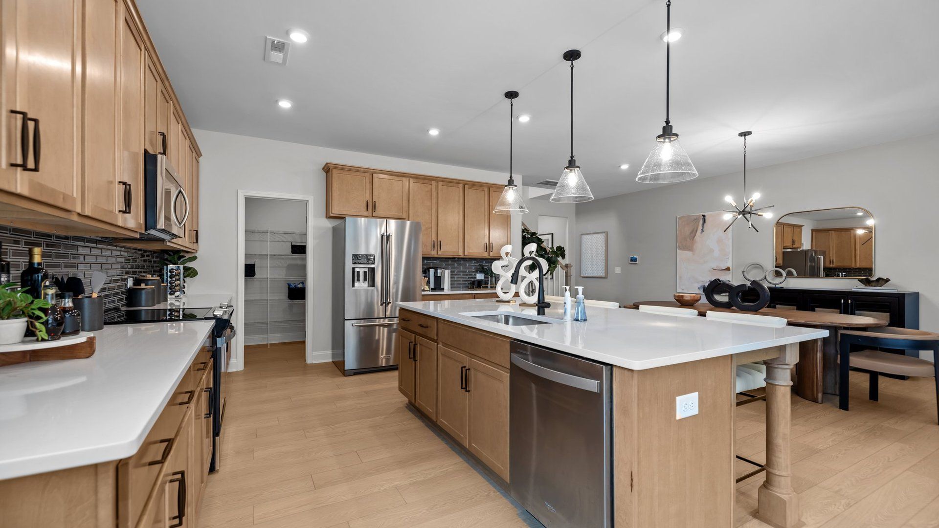 Kitchen with large centered island, quartz countertops, and premium lighting, in the Adaline Plan by DRB Homes Charlotte, NC