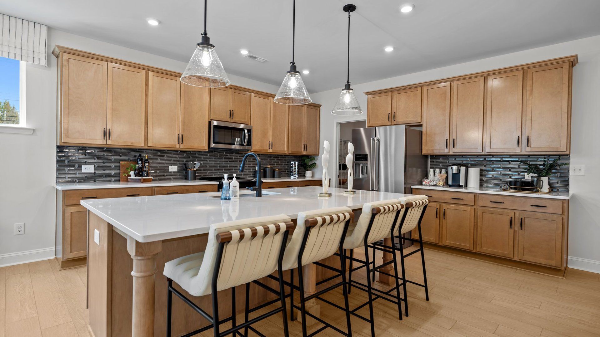 Kitchen island with quartz countertops, premium lighting, and abundant cabinetry. The Adaline plan by DRB Homes Charlotte, NC