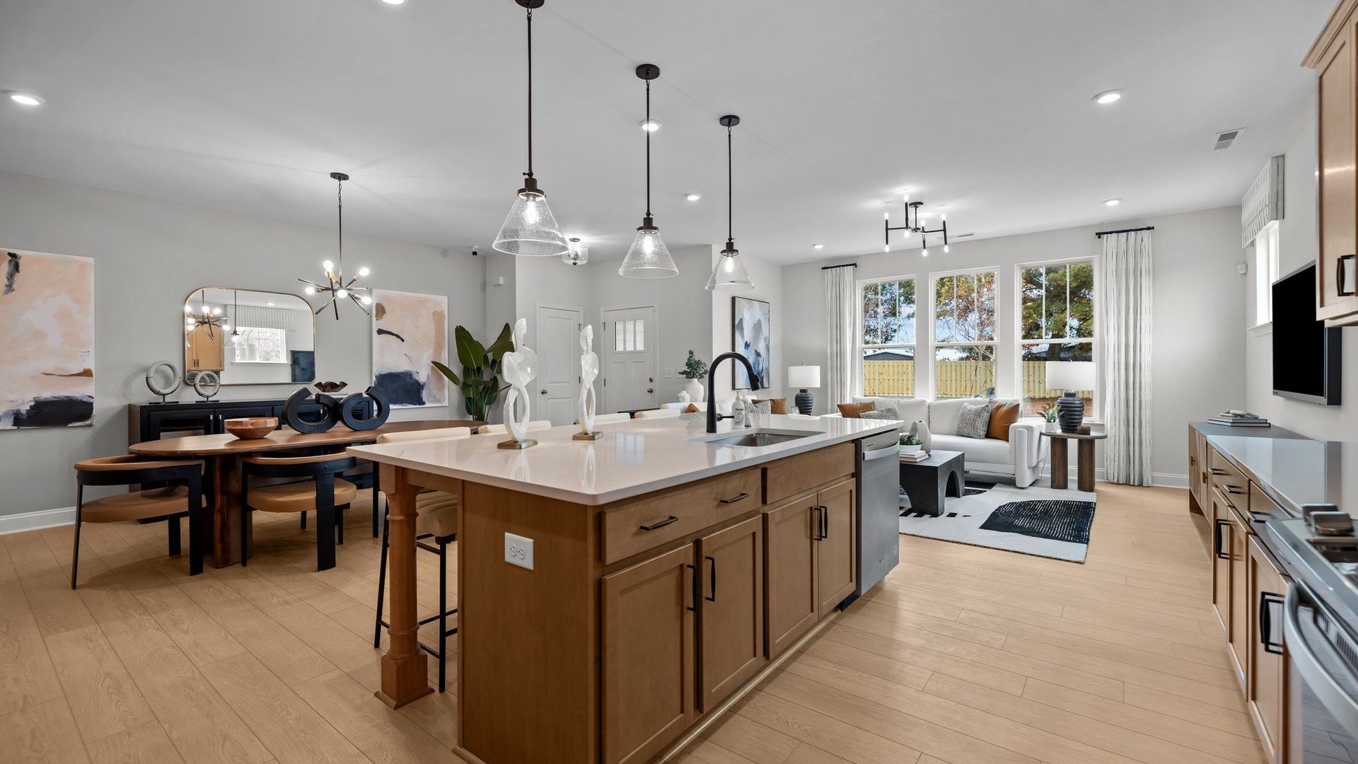 Spacious open-floor concept main level offers elevated ceiling, kitchen, pendant lighting, dining, and family room. DRB Homes