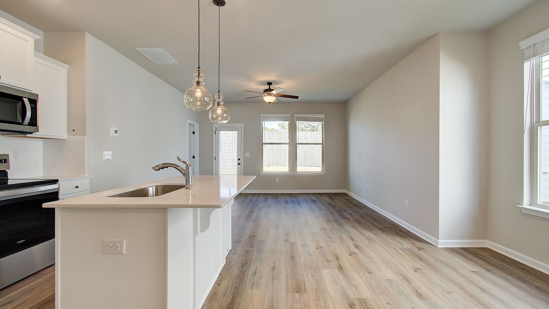 Spacious living area with abundant natural light, neutral walls, and recessed lighting
