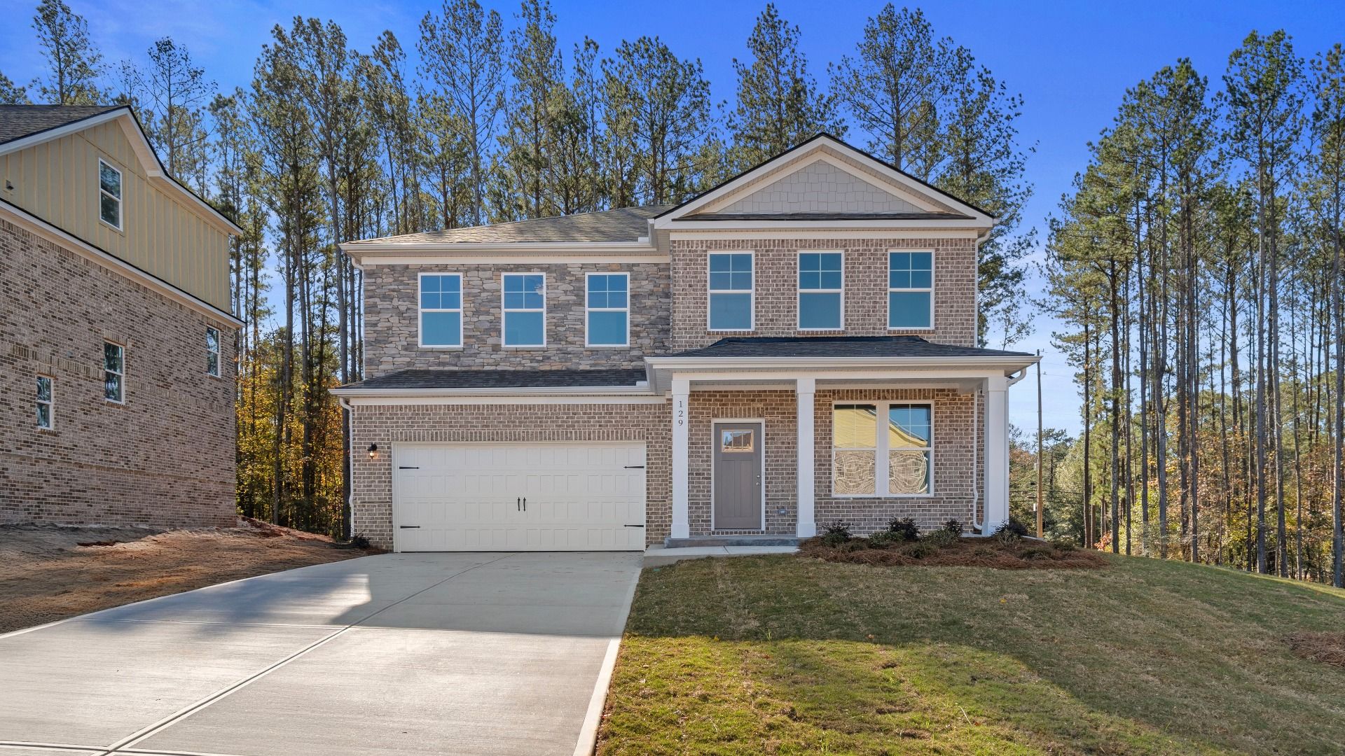 Ridgewood two-story brick exterior home with stone accent and two-car front-entry garage at Bowers Farm in McDonough, GA.