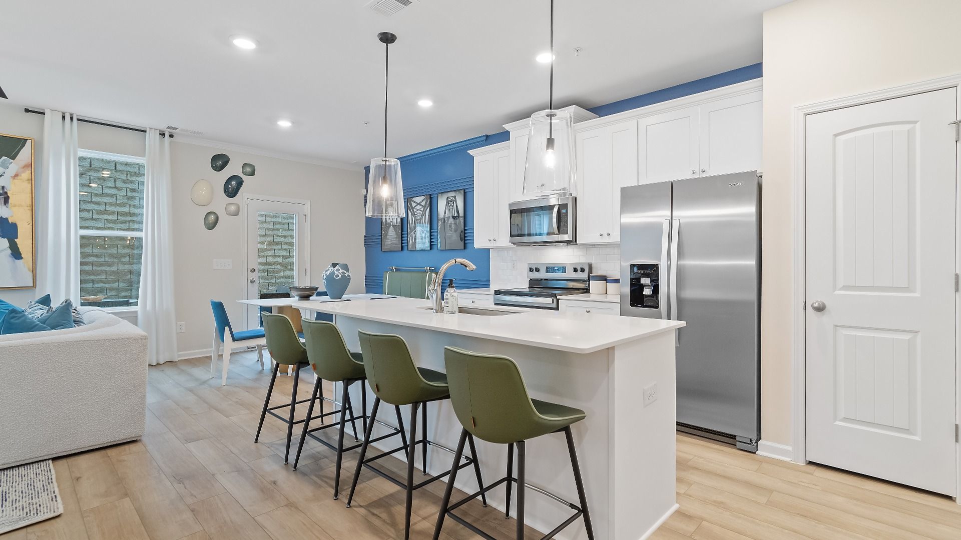 Modern kitchen in new construction townhome in Riverdale, GA with large island, quartz countertops, and stainless appliances.