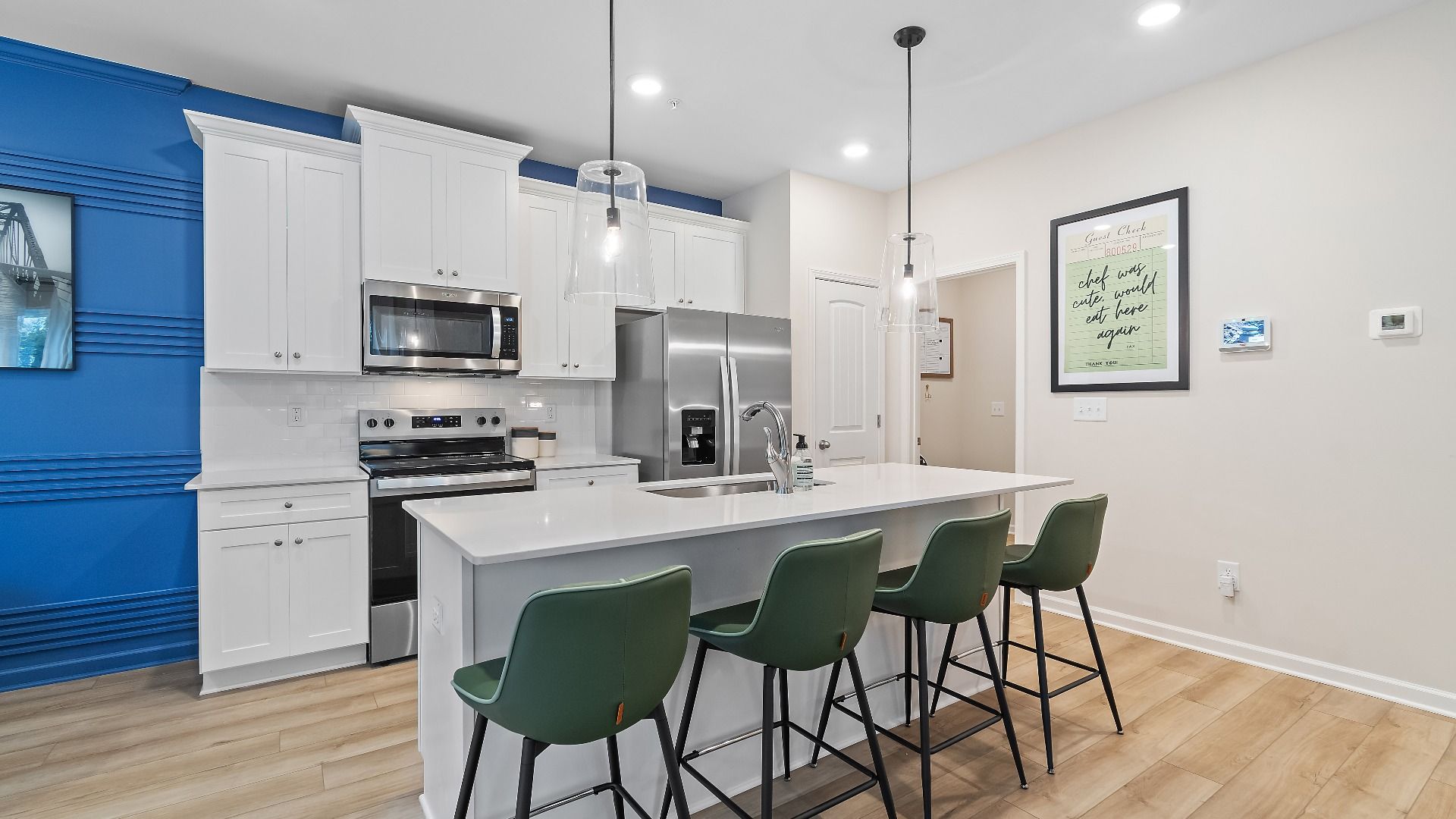 Modern kitchen with large island, pendant lighting, and open layout in new townhome at Auburn Ridge in Riverdale, GA.