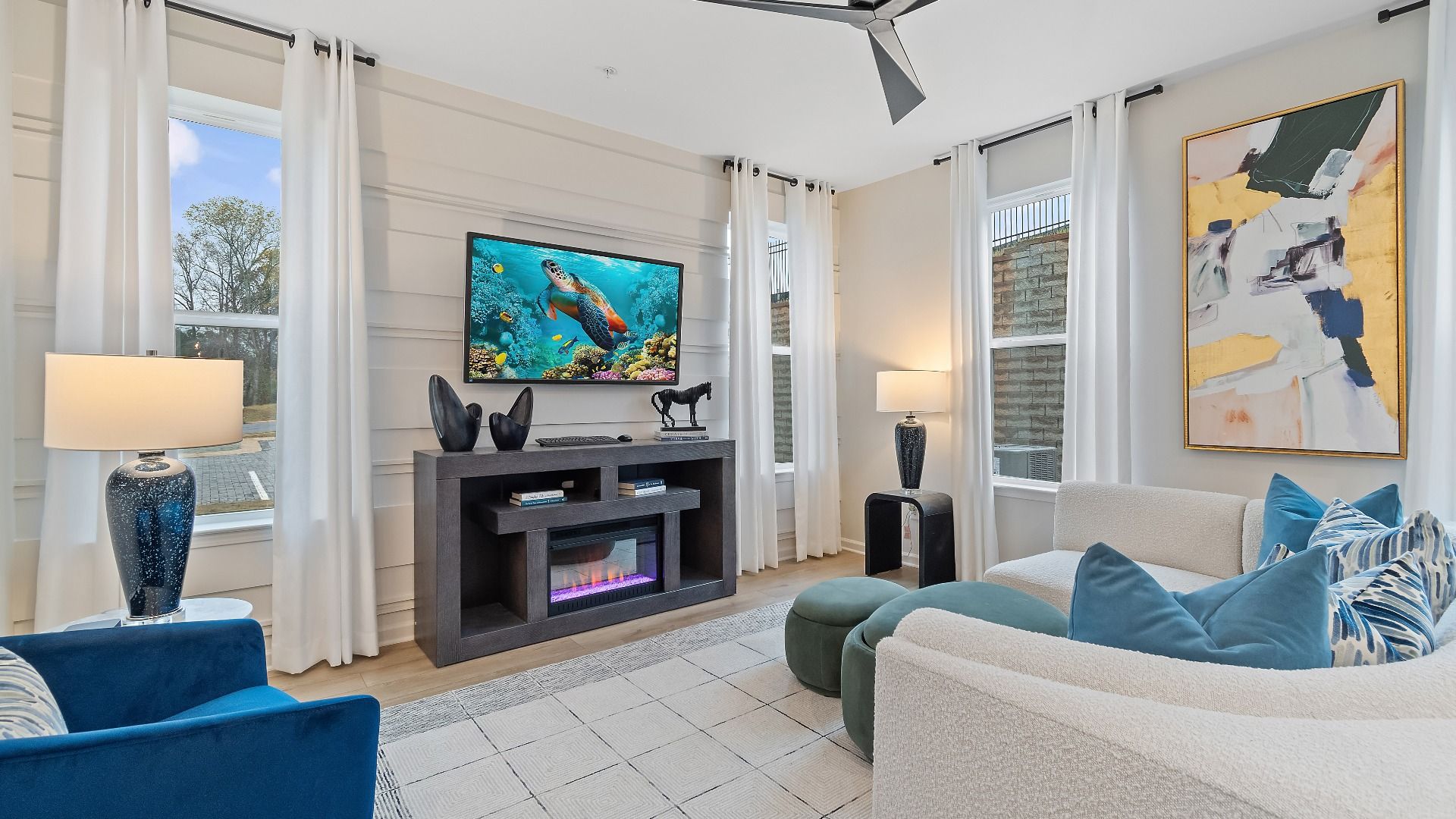 Spacious family room with large windows, ceiling fan and open layout in new construction townhome at Auburn Ridge.