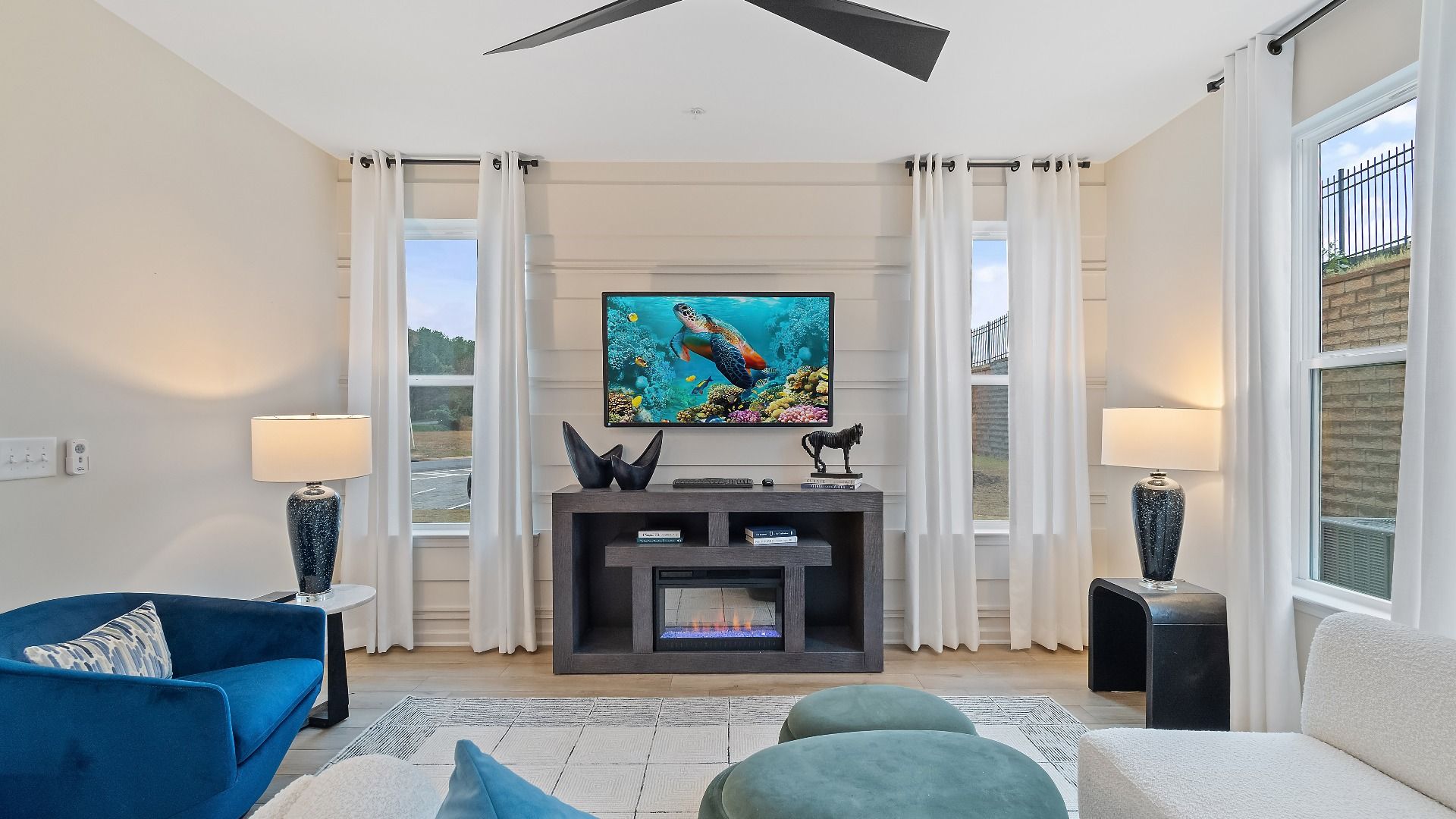 Spacious family room with large windows, ceiling fan and open layout in new construction townhome in Riverdale, GA.