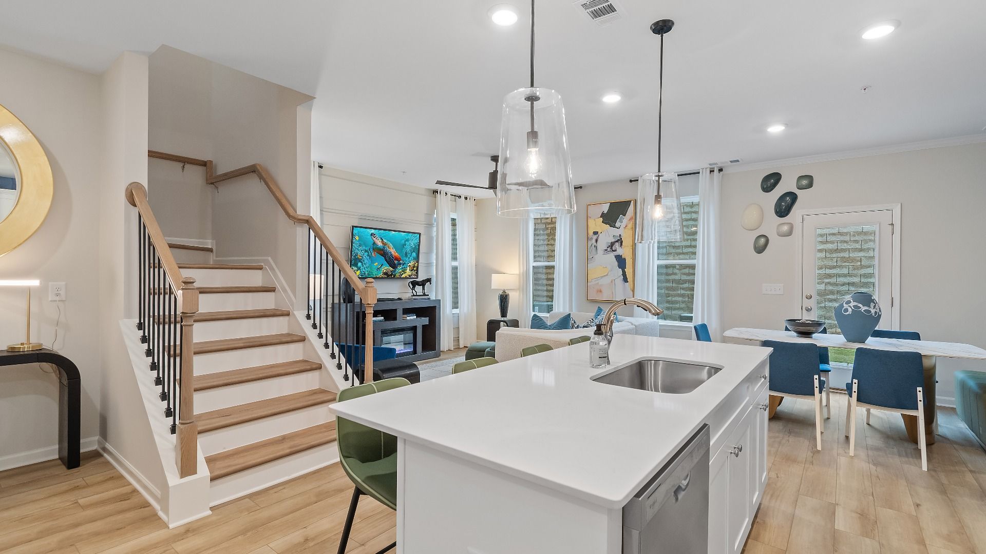 Kitchen island overlooking family room, breakfast area, and staircase in new townhome at Auburn Ridge in Riverdale, GA.