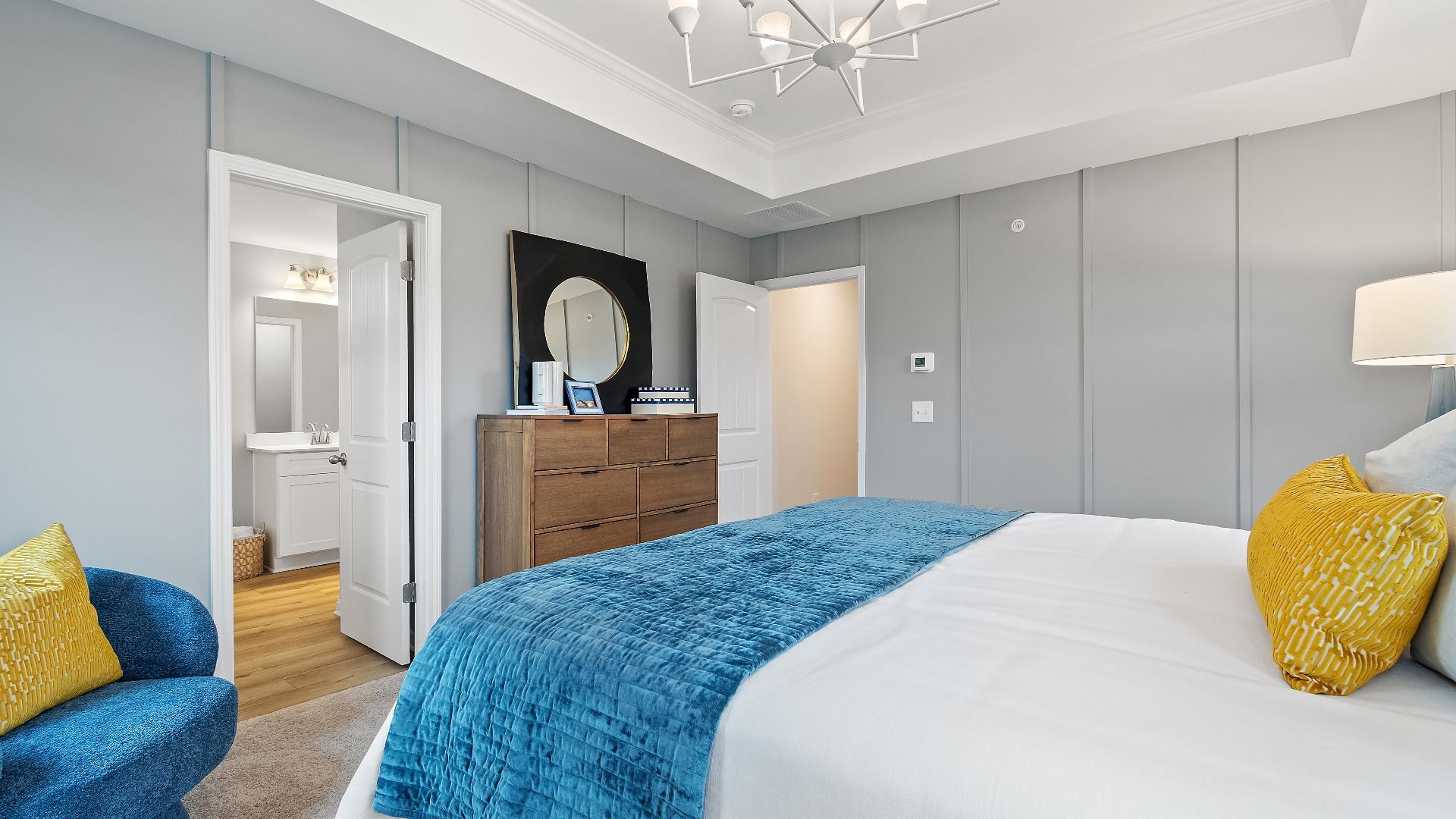 Stylish primary suite in new construction townhome featuring tray ceiling and bright modern palette in Auburn Ridge.