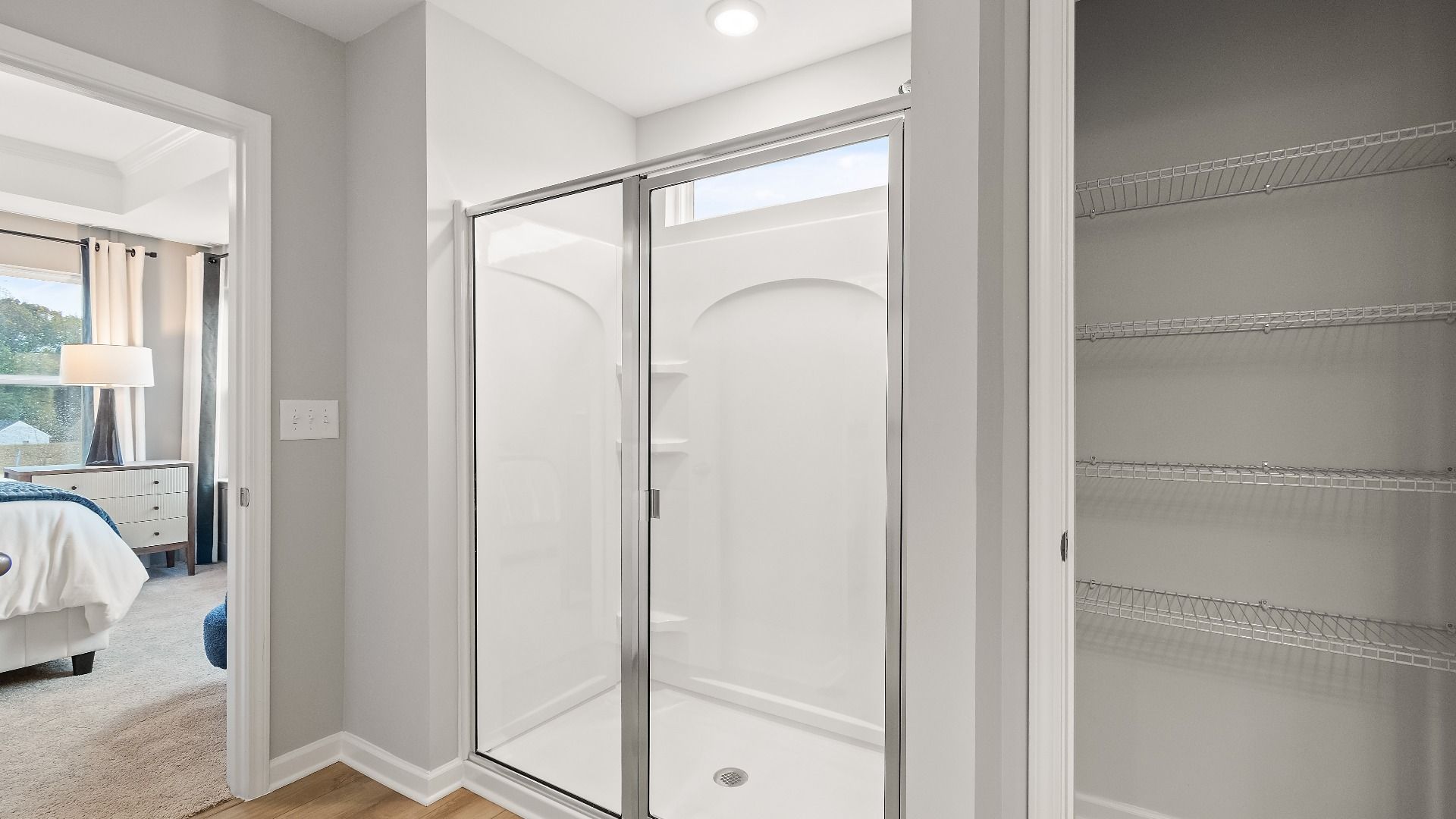 Modern bathroom featuring walk-in shower with glass door and sleek finishes in new construction townhome in Riverdale, GA.