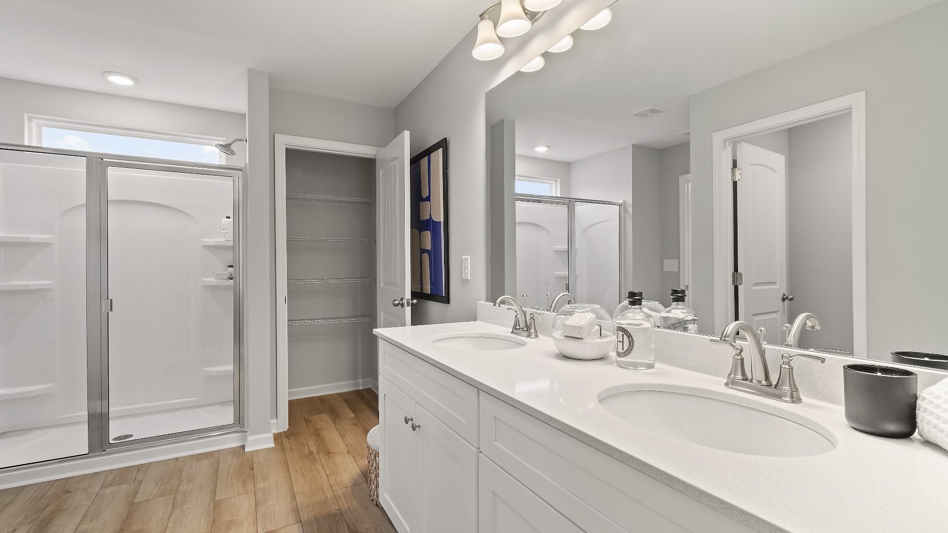 Bathroom with double vanities, quartz countertops, modern fixtures, and large mirror in new townhome at Auburn Ridge.