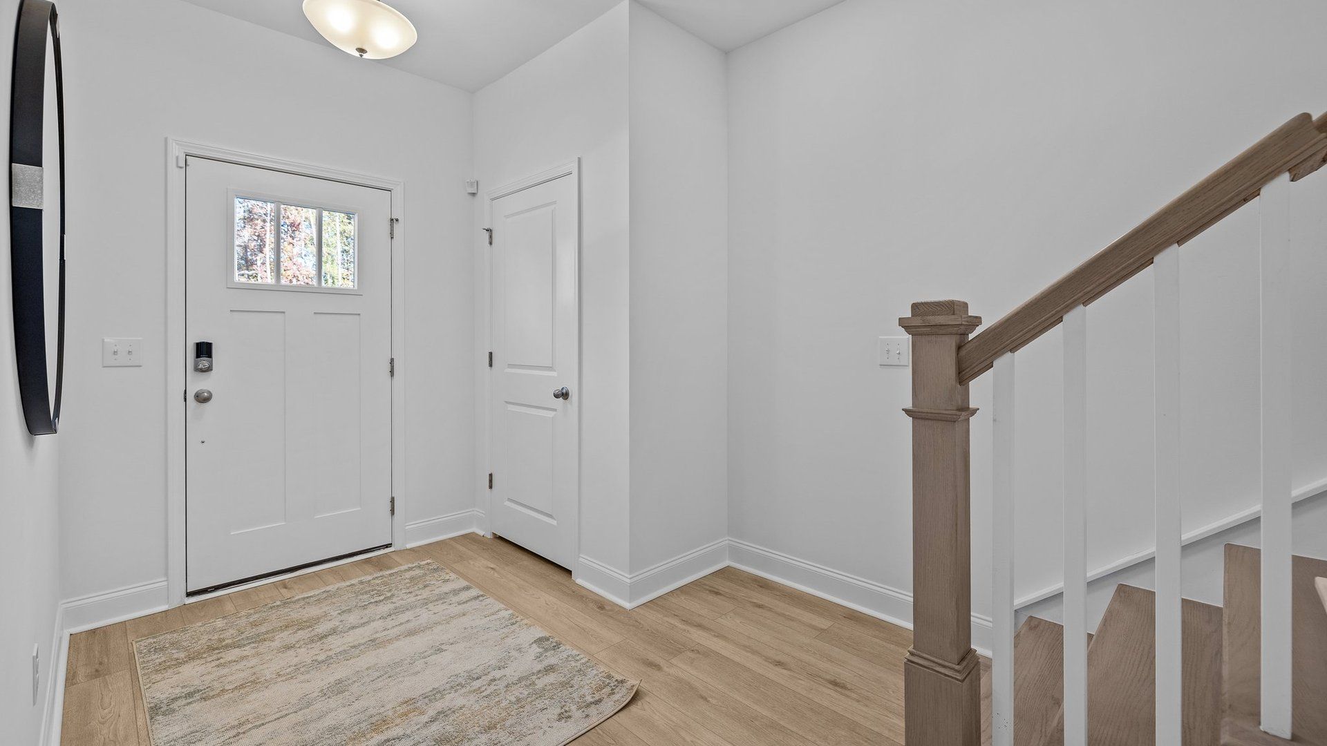 Welcoming entrance foyer with elevated ceiling, coat closet, and solid oak tread stairs. By DRB Homes in Charlotte, NC