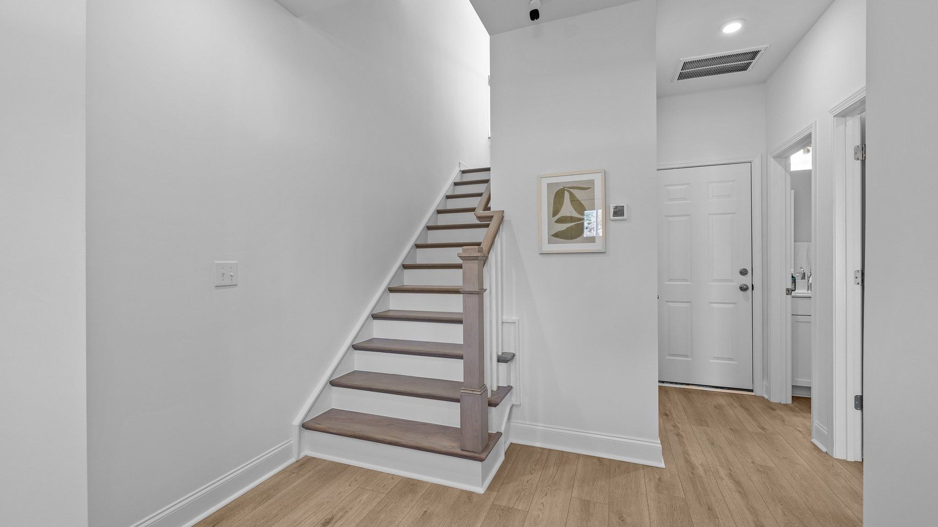 Convenient entrance from the 2-car garage, full bathroom, bedroom on the main level, and solid oak trad stairs, by DRB Homes.