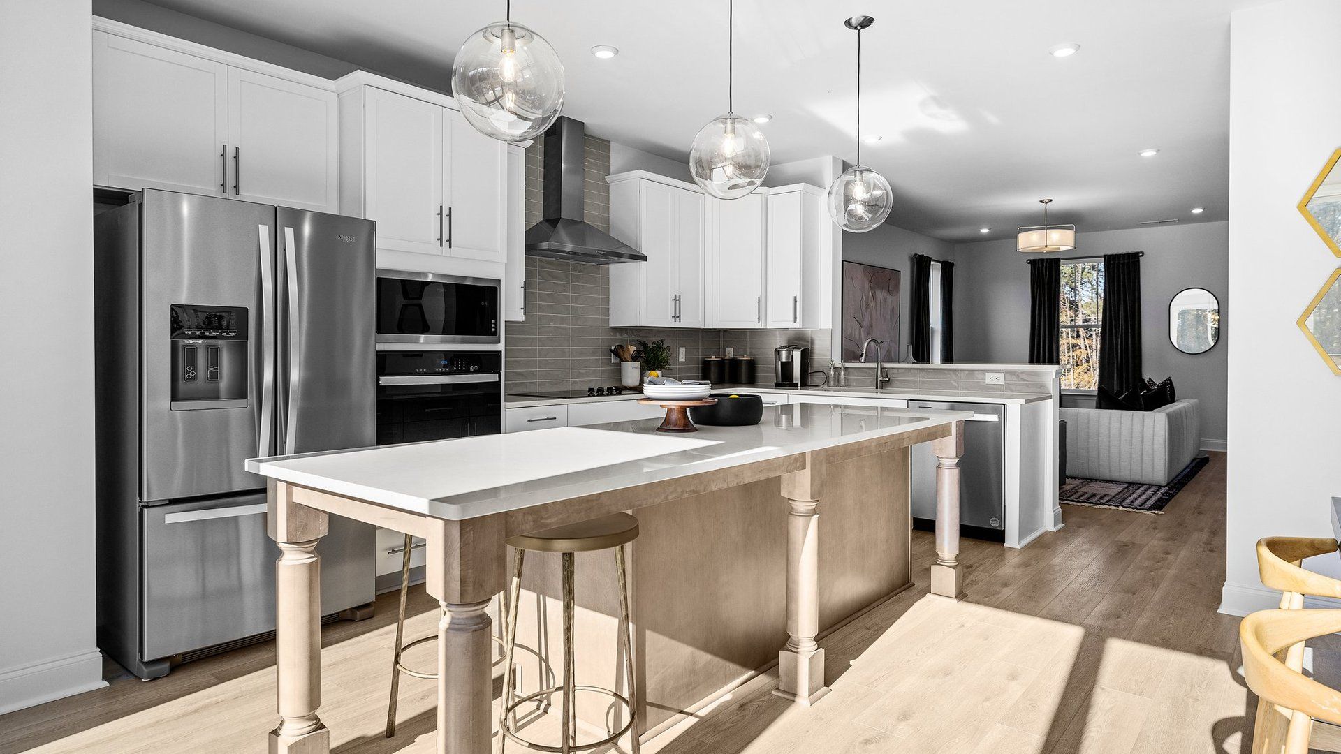 Gourmet kitchen with extended island, vented hood, wall oven/microwave, and premium lighting by DRB Homes in Charlotte, NC.