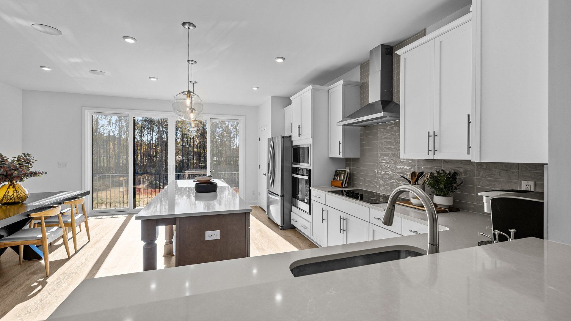 Bright gourmet kitchen with premium double slider doors and premium lighting in the Landon Design by DRB Homes Charlotte, NC