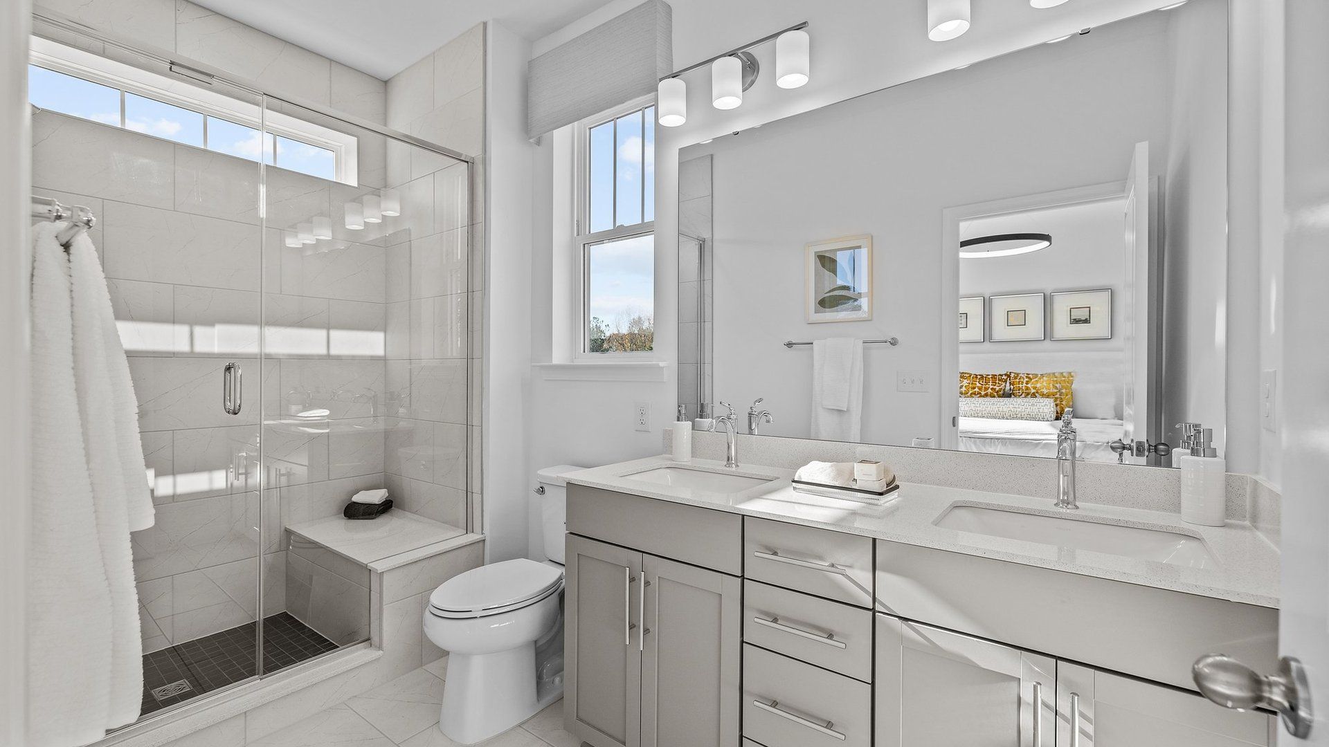 Fully tiled shower with seat, comfort-height cabinets, and dual undermount sinks in the Landon Design by DRB Homes Charlotte