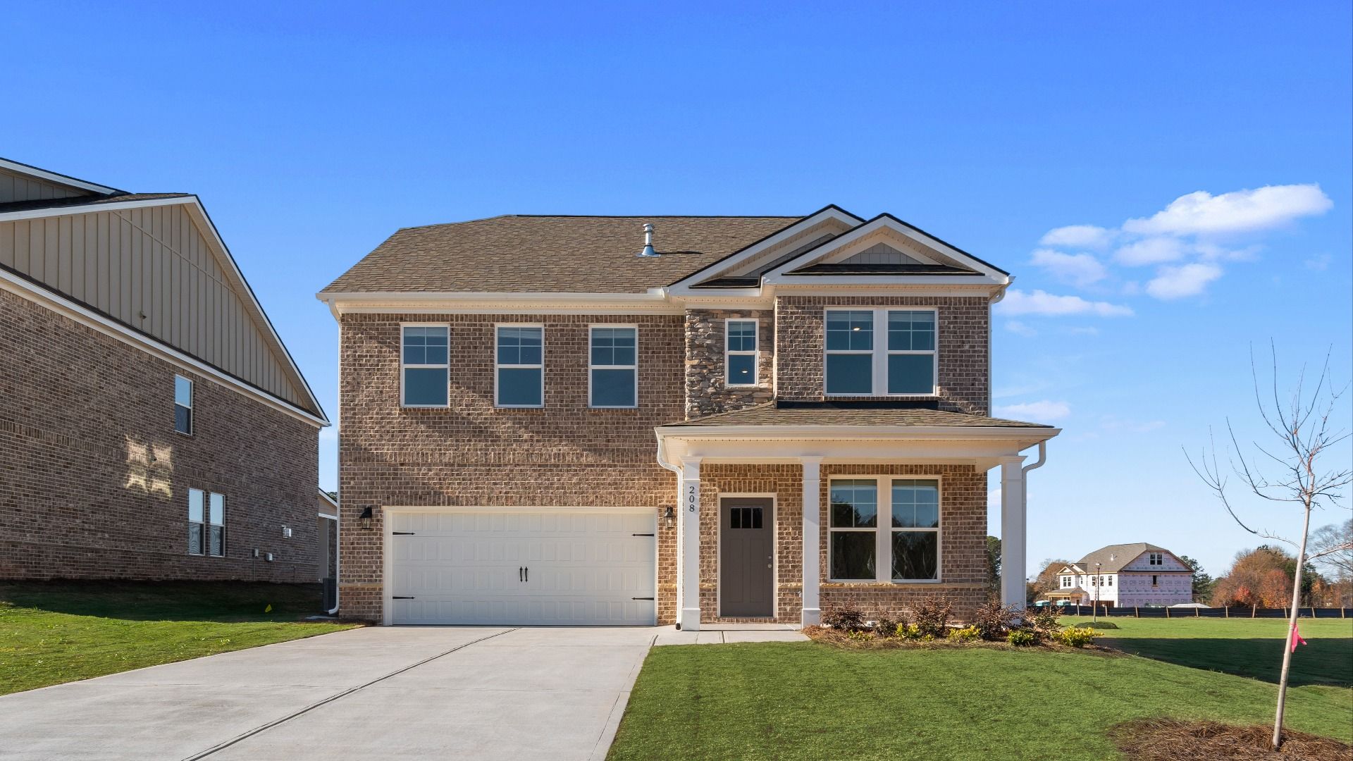 Pelham new construction single-family home with brick-dominant exterior and two-car front-entry garage at Burchwood.