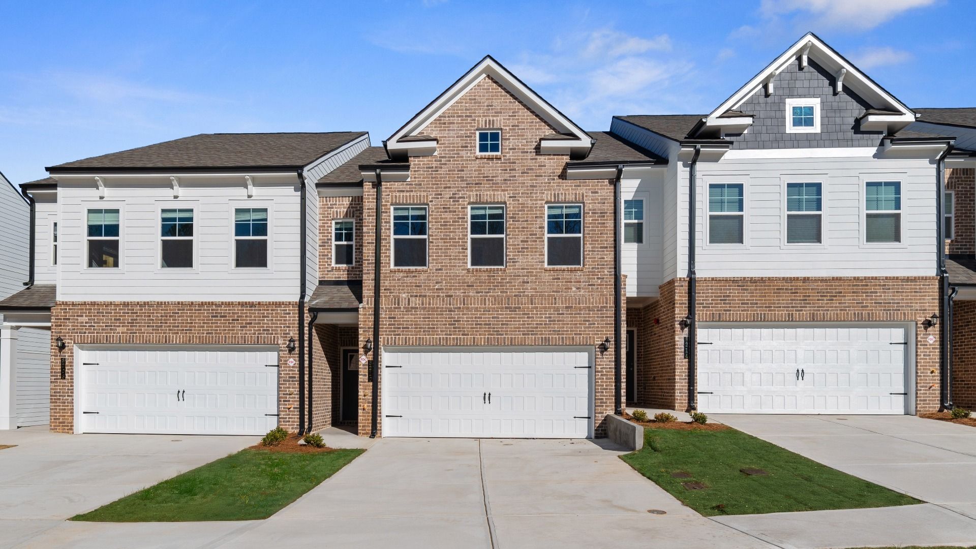 New construction townhome with brick front and two car garage in Riverdale, GA.