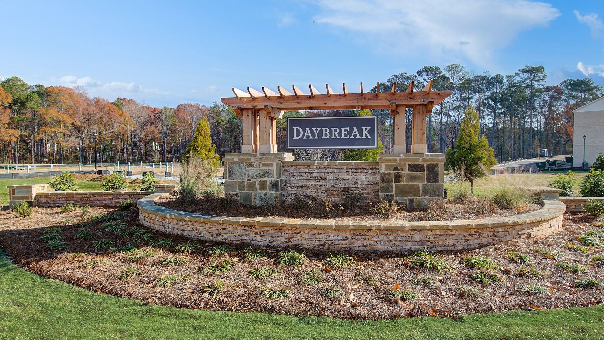 Landscaped Daybreak community entry sign with brick and stone design in Newnan, GA.
