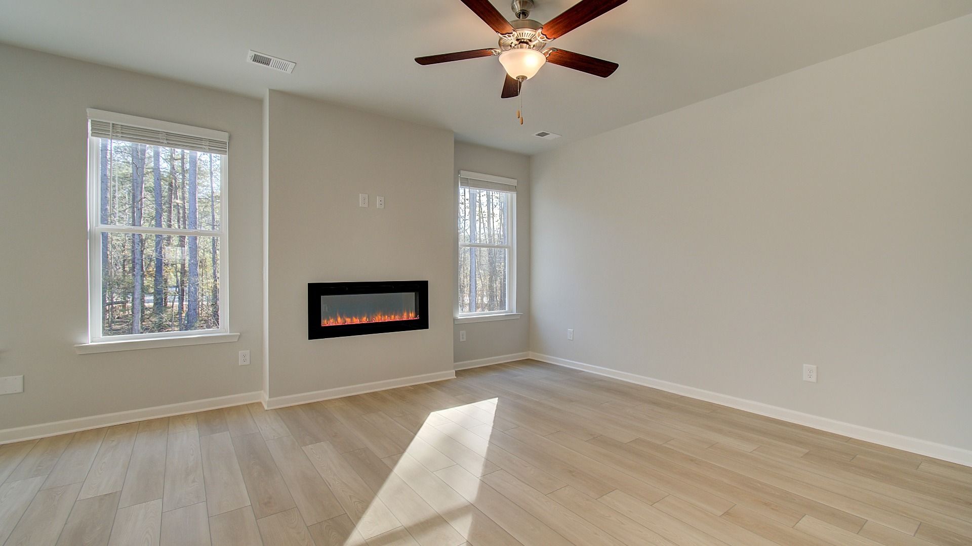 Expansive Pelham family room with LVP flooring, electric center fireplace, and natural light at Bowers Farm.