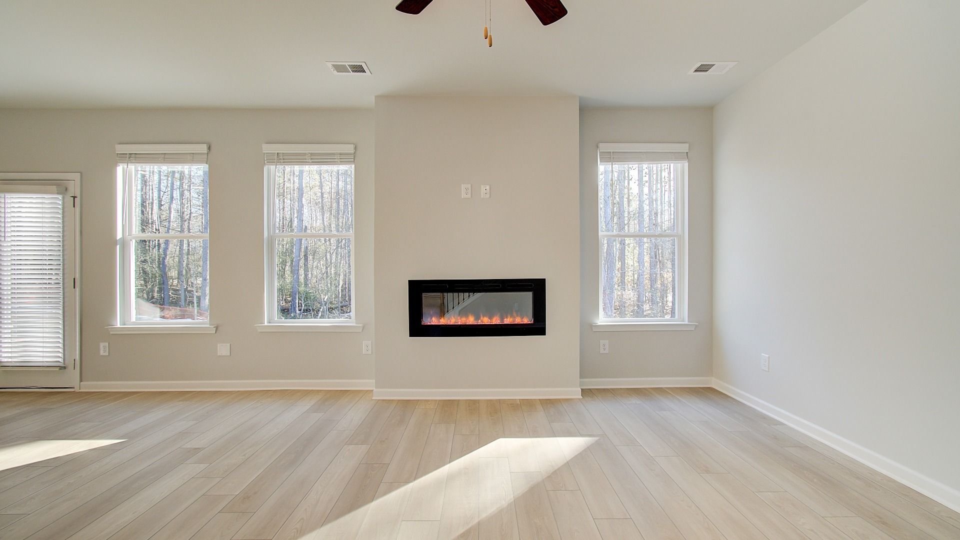 Expansive Pelham family room with LVP flooring, electric center fireplace, and natural light at Bowers Farm.
