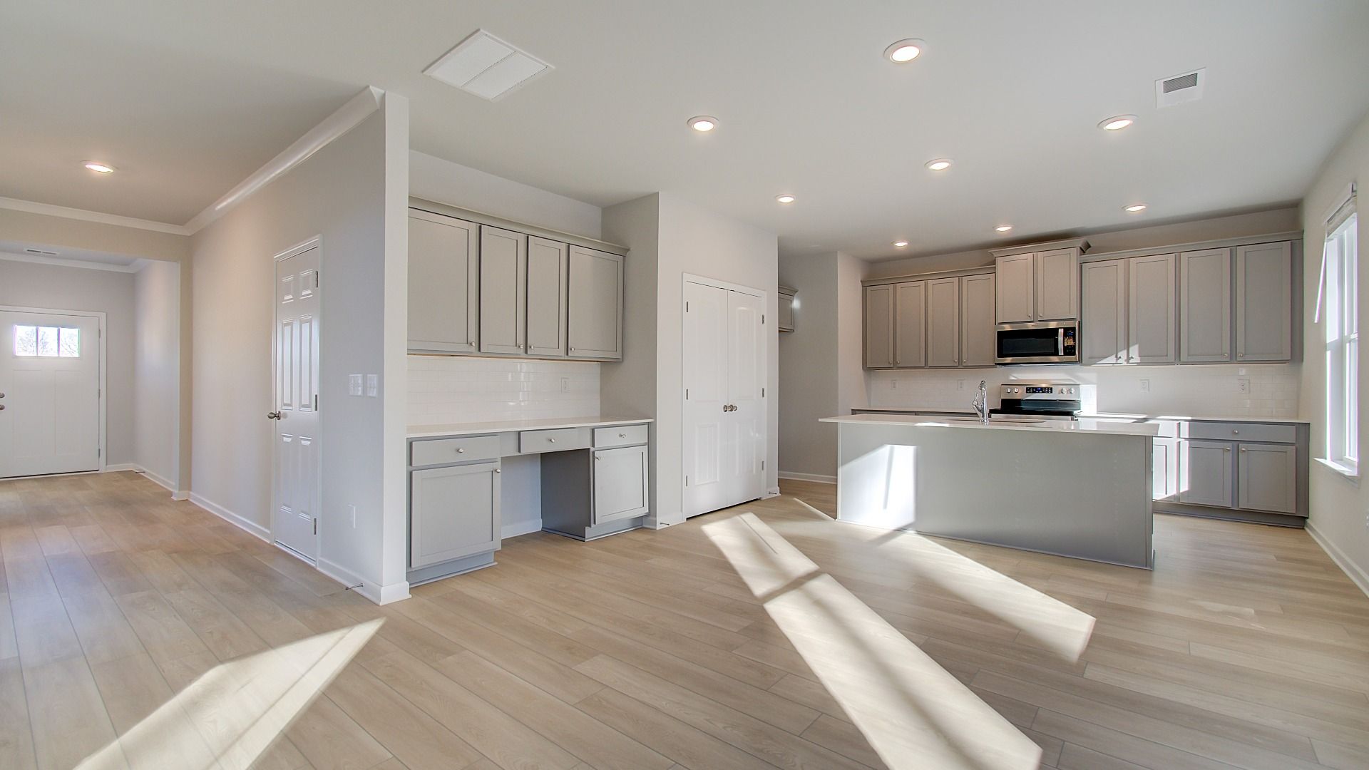 Expansive Pelham kitchen with abundant cabinetry, center island, and neutral modern finishes at Bowers Farm in McDonough, GA.