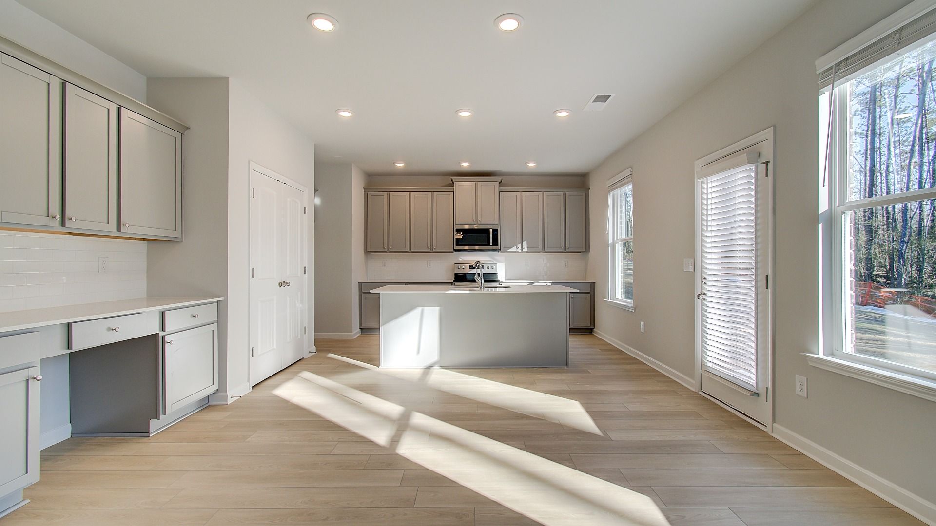 Expansive Pelham kitchen with abundant cabinetry, center island, and neutral modern finishes at Bowers Farm in McDonough, GA.
