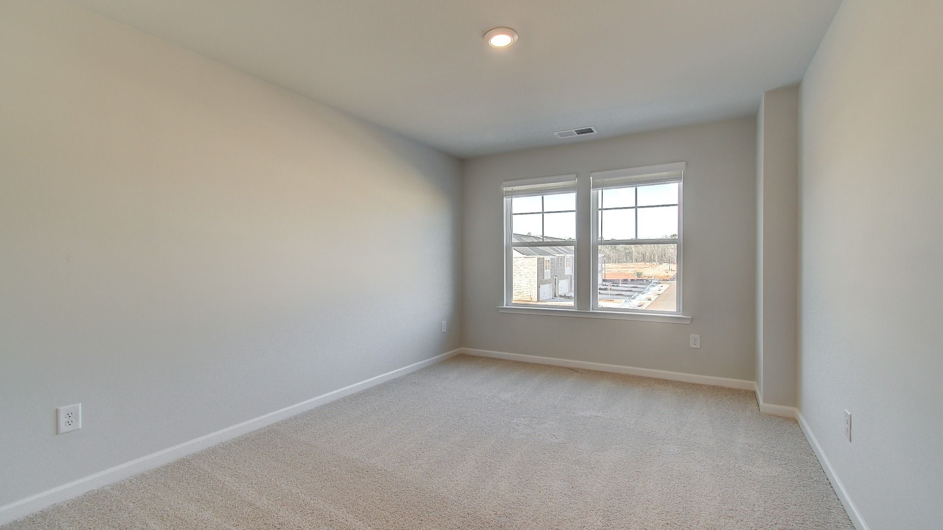 Spacious loft for flexible use with natural light and carpet flooring in the Pelham at Bowers Farm in McDonough, GA.