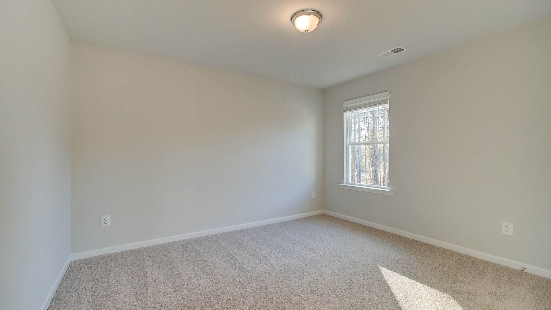 Secondary bedroom with overhead lighting, natural light, and carpet flooring in the Pelham at Bowers Farm.