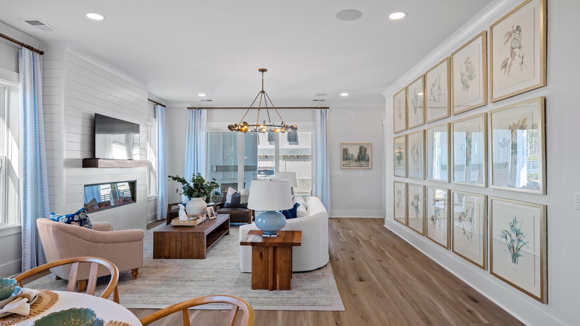 Living Room- Beaufain Model Home in Midtown at Nexton in by DRB homes offering an electric fireplace with lots of windows