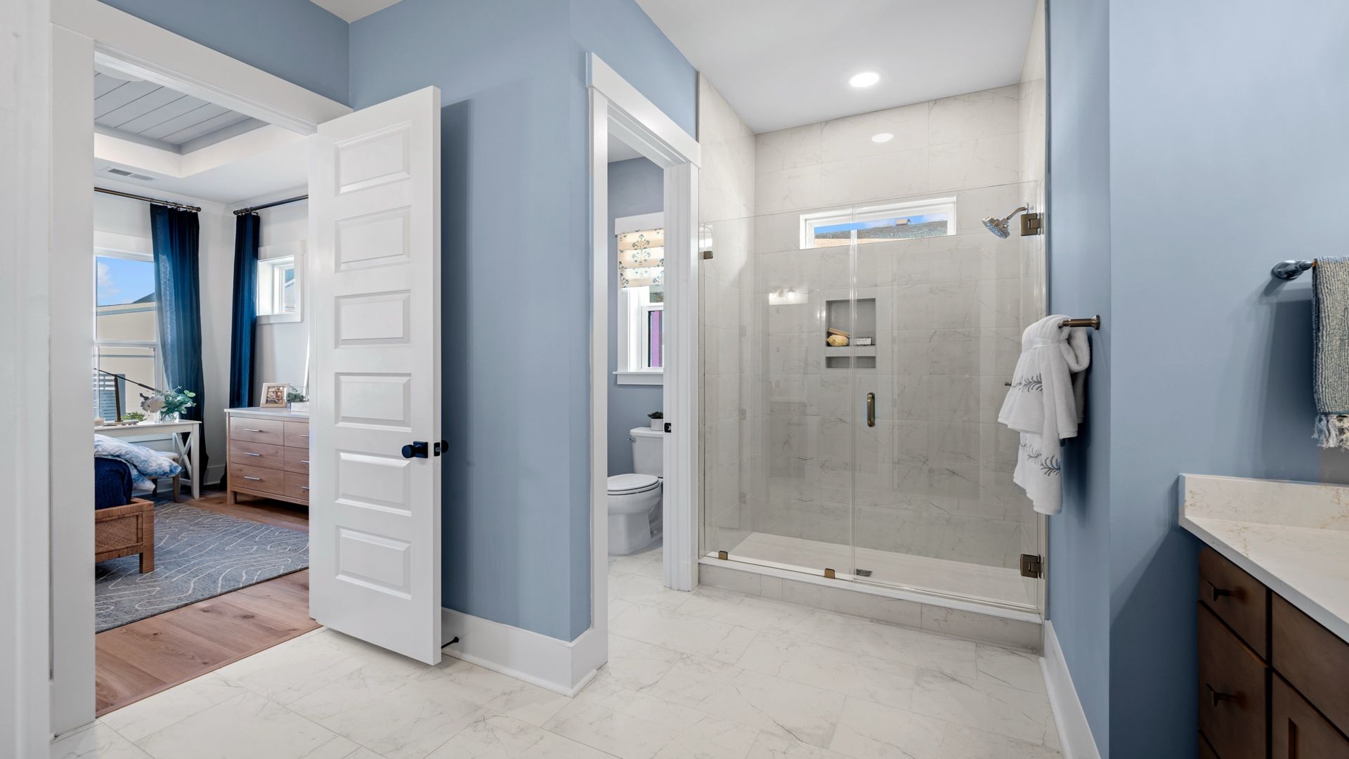 The Primary Bathroom at Midtown at Nexton by DRB homes offering tile shower and dual vanity