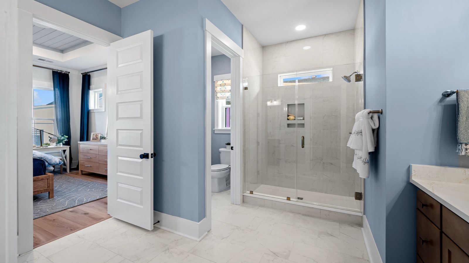 The Primary Bathroom at Midtown at Nexton by DRB homes offering tile shower and dual vanity