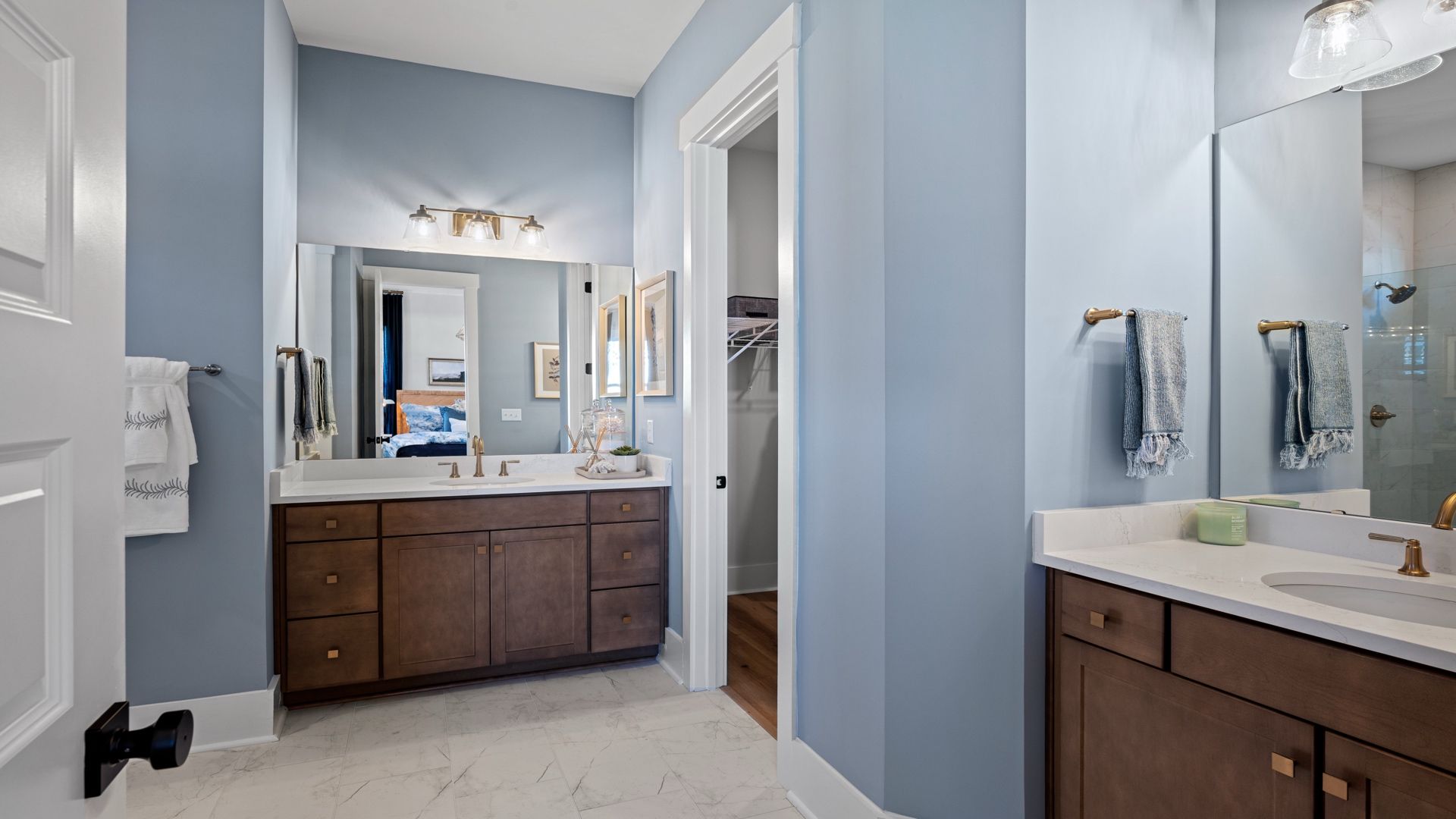The Primary Bathroom at Midtown at Nexton by DRB homes offering tile shower and dual vanity