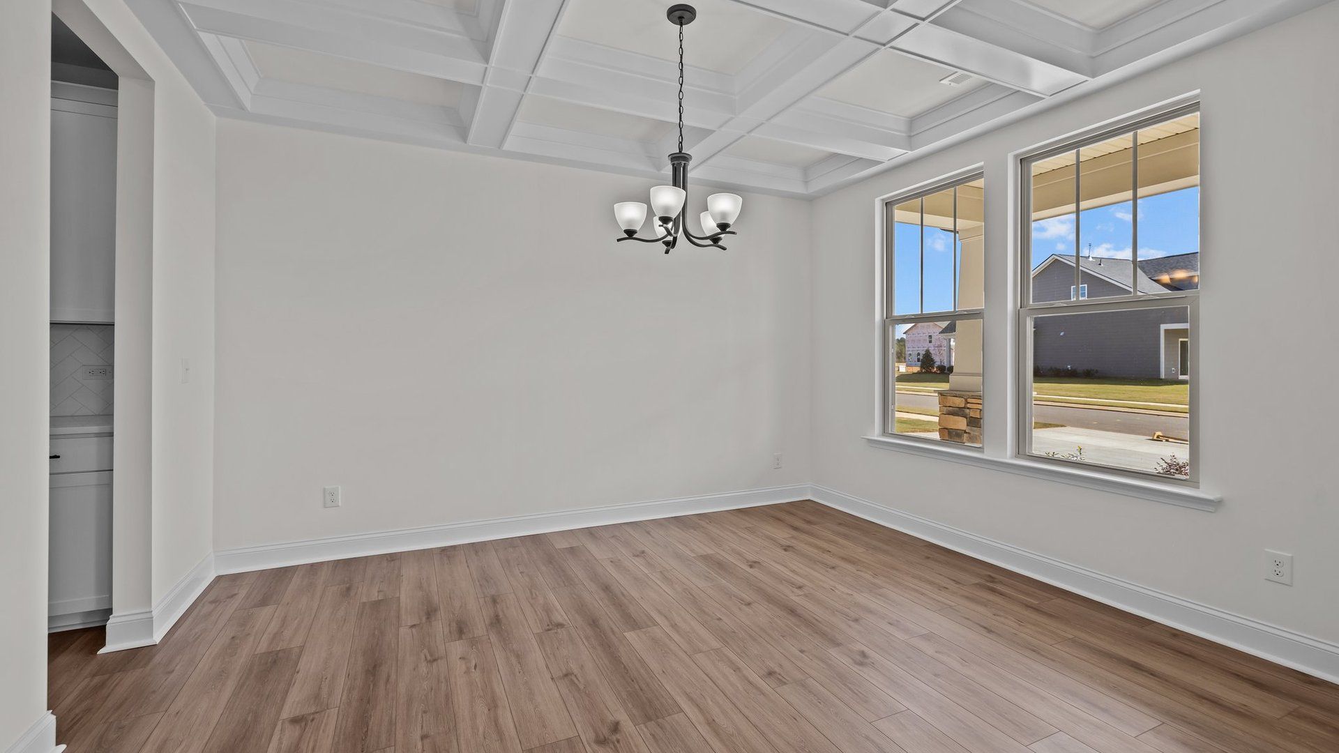 Norris Design dining with raised coffered ceiling and large windows for abundant natural light. By DRB Homes in York, SC