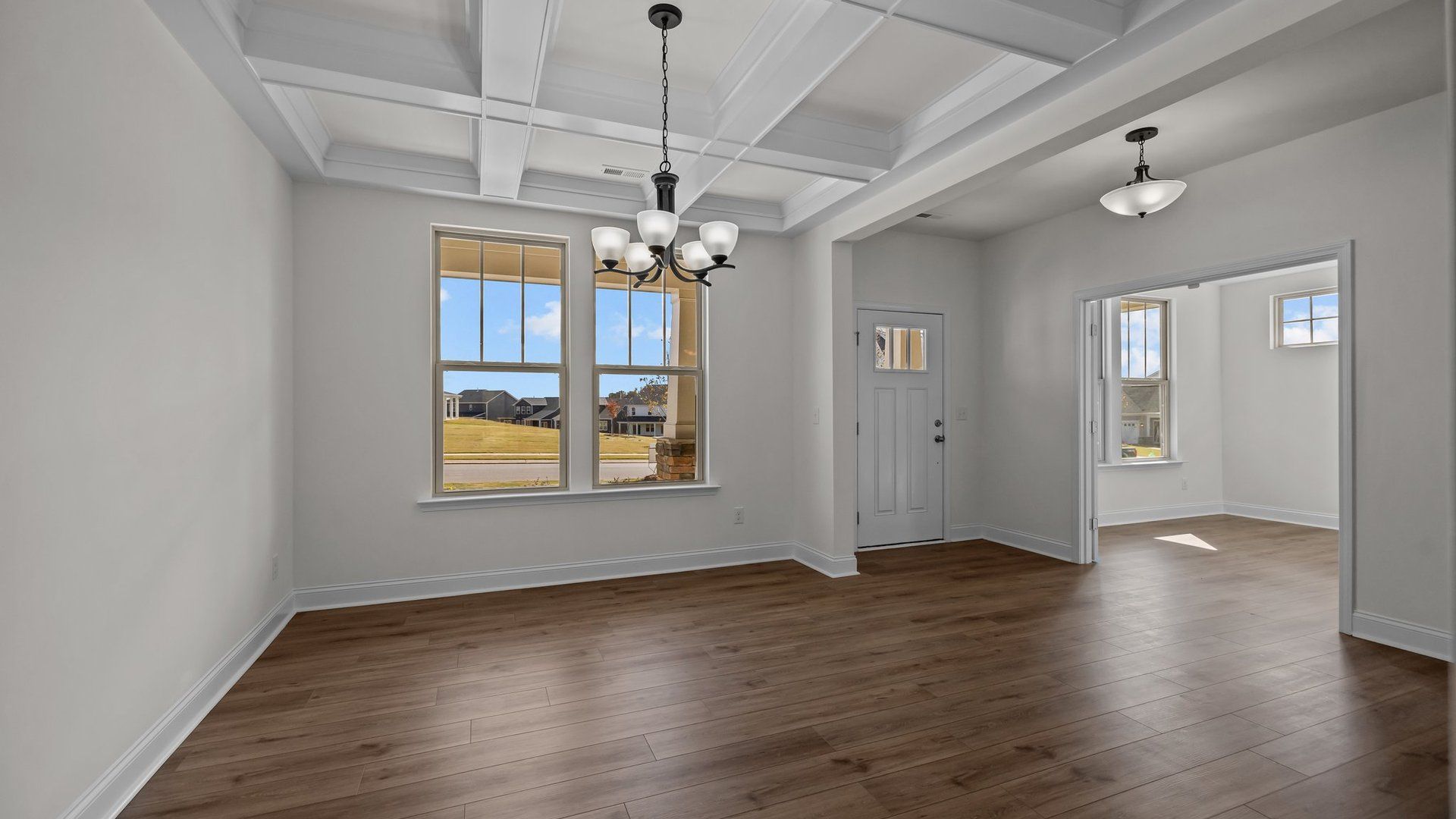 Norris Design dining with raised coffered ceiling and large windows for abundant natural light. By DRB Homes in York, SC