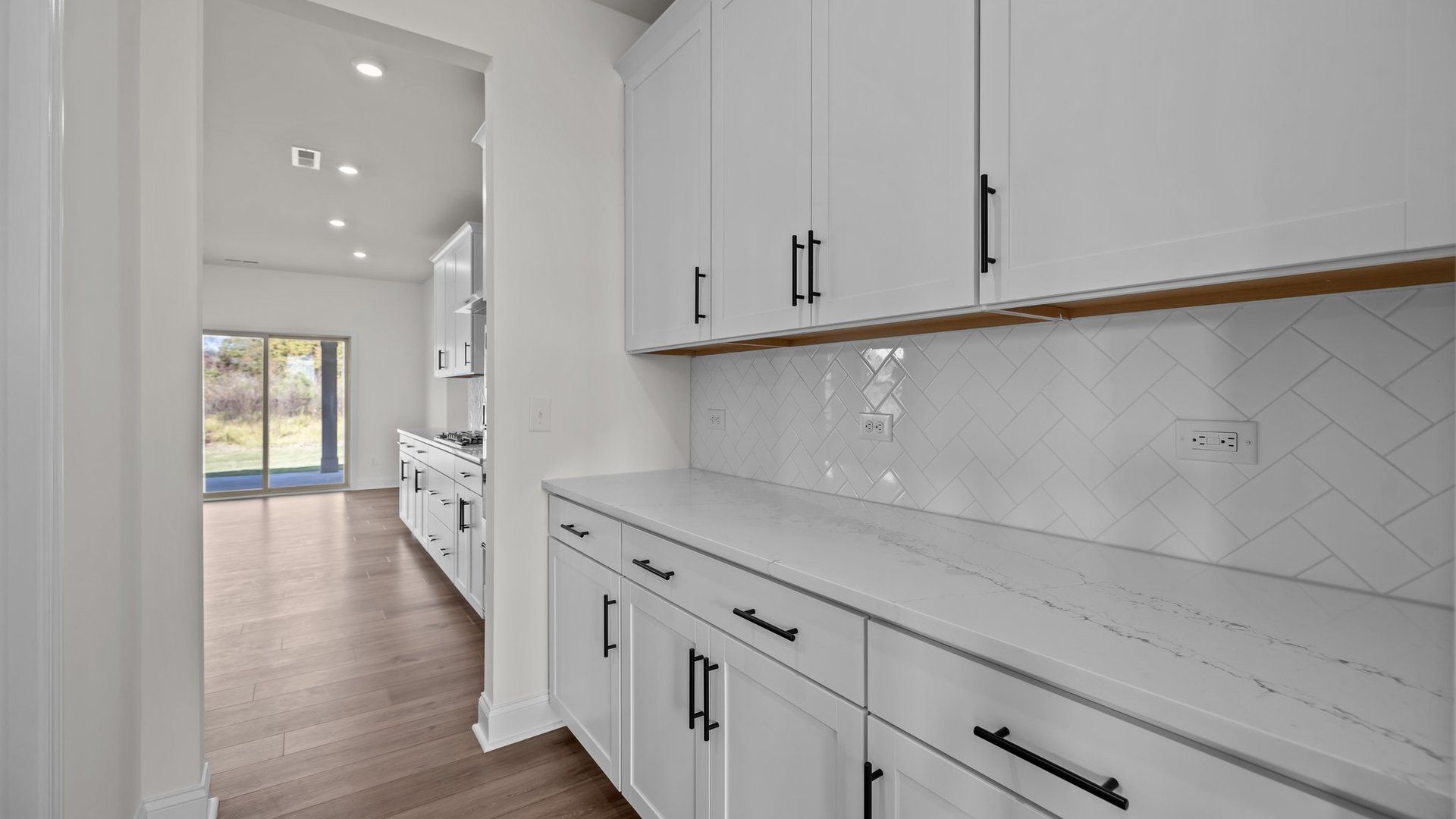 Norris Design pass-through butler's pantry with abundant cabinets. At Lakeside Glen by DRB Homes in York, SC.