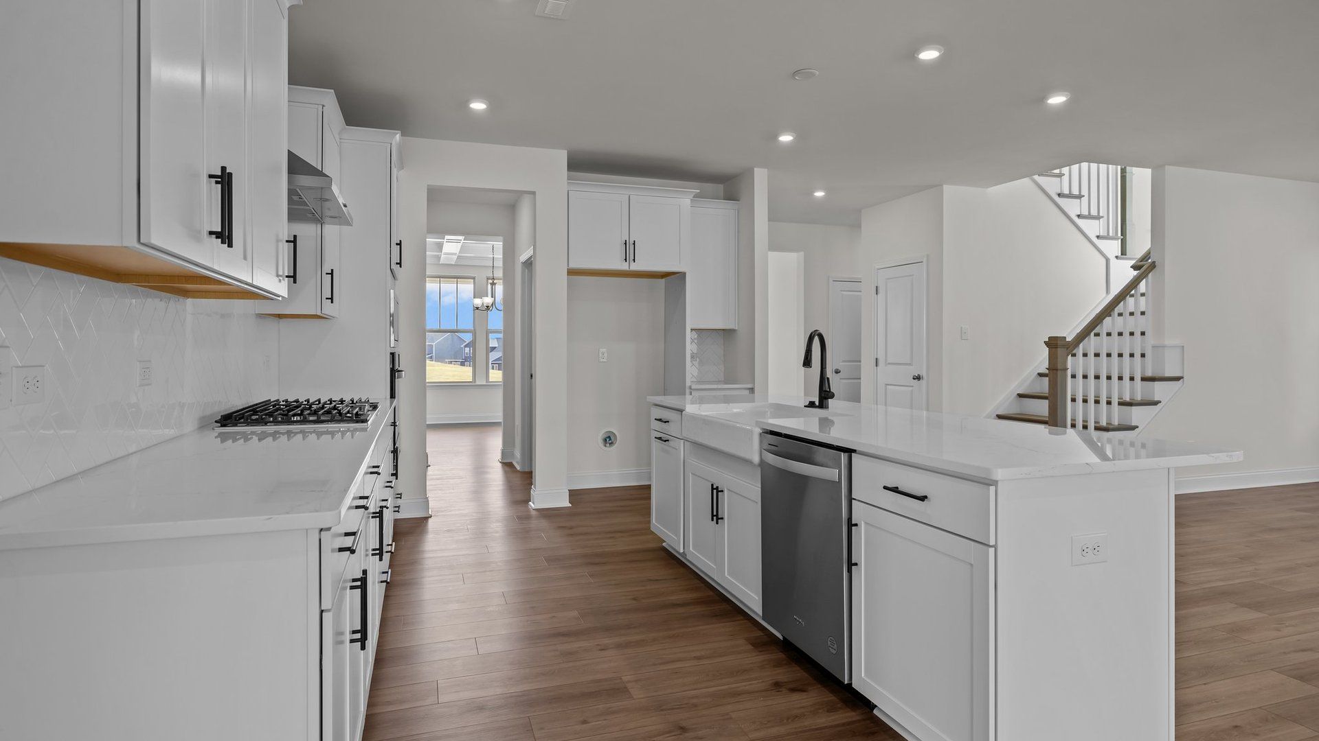 Norris Design gourmet kitchen island and butler's pantry pass through into dining. At Lakeside Glen by DRB Homes in York, SC.