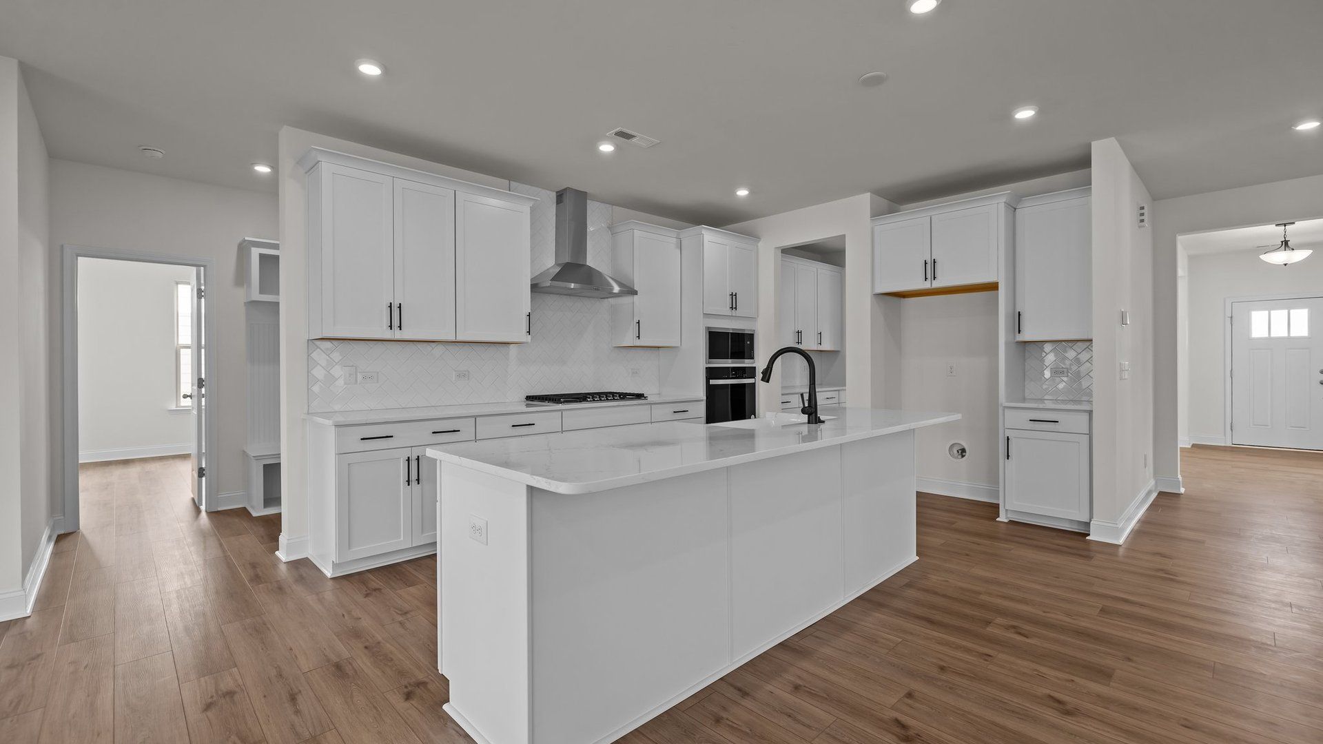 Gourmet Kitchen with premium cabinetry, wall oven, built-in microwave, vented hood, and large island in the Norris Plan