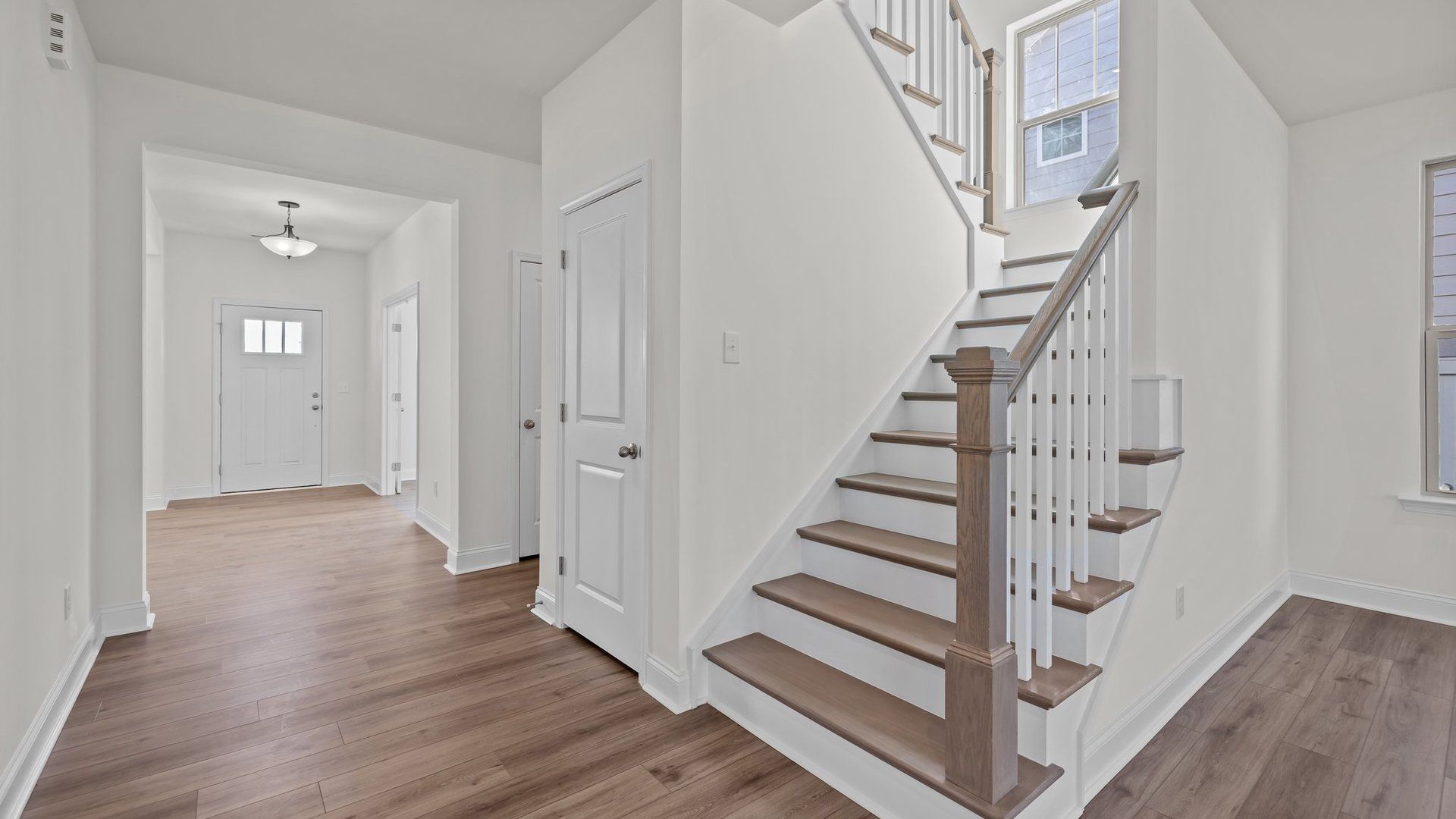 Norris Design wide entry and stairs with solid oak treads and open rail. At Lakeside Glen by DRB Homes in York, SC.