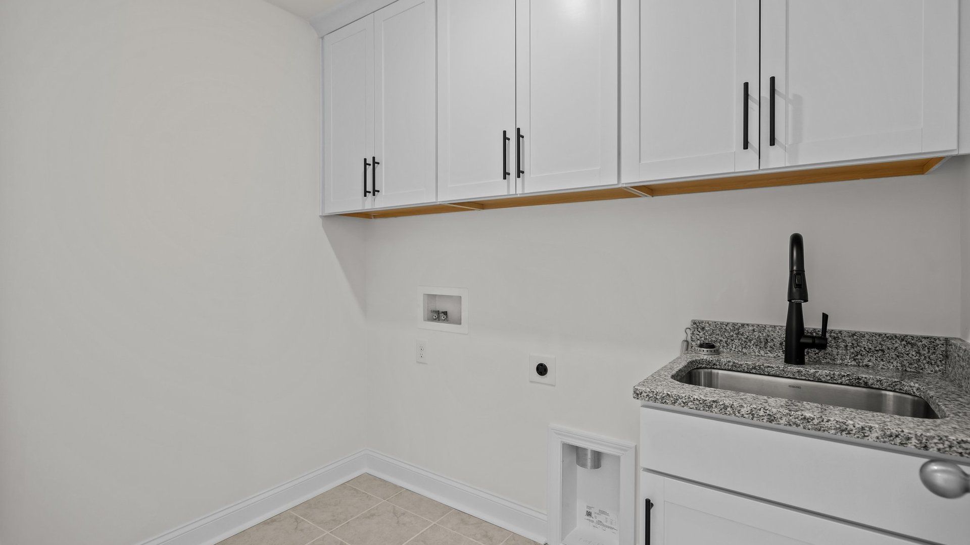 Conveniently located laundry room with sink and premium cabinets, in the Norris Design by DRB Homes in York, SC