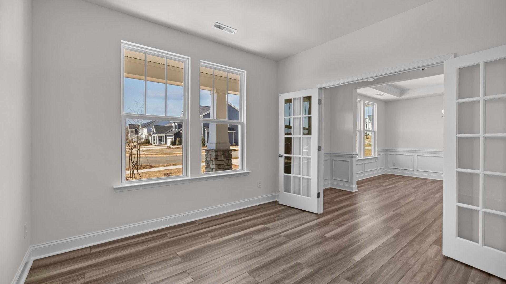 Flexible and bright study with elevated ceiling, large windows, and double French doors, in the Norris Design by DRB Homes