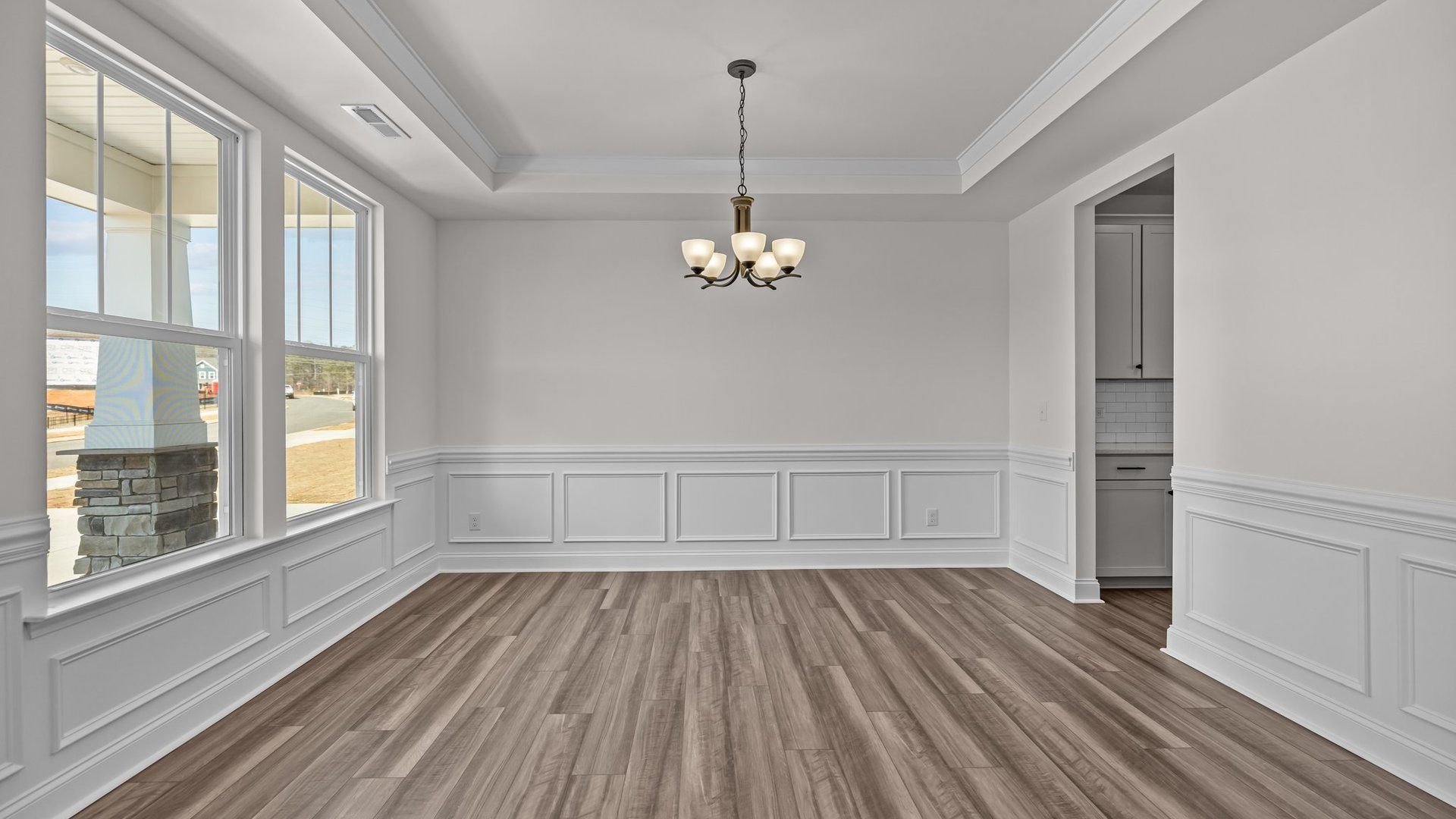 Elegant dining with pass-through butler's pantry, elevated tray ceiling, and premium trim, in the Norris Design by DRB Homes