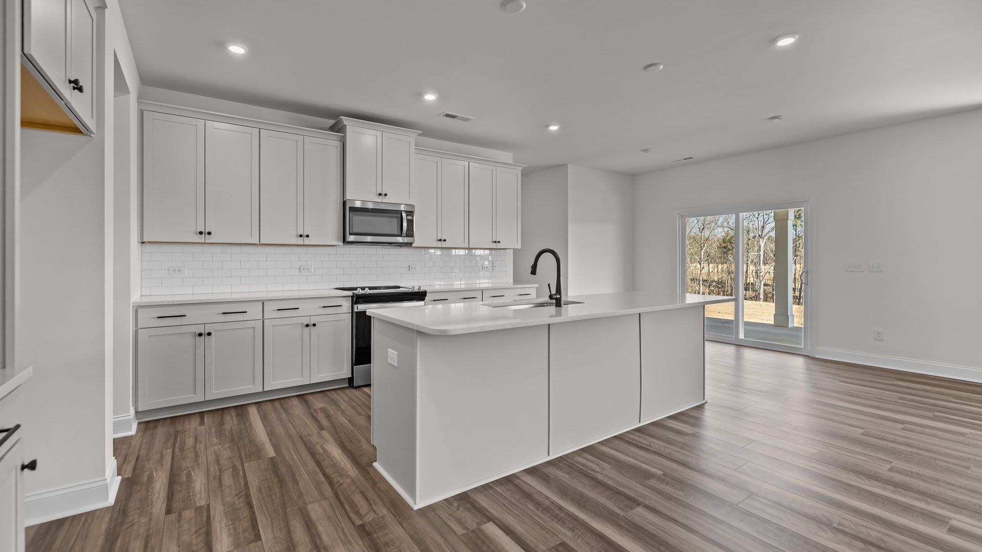 Spacious kitchen with elevated ceiling, large island, and plentiful cabinetry, in the Norris Design by DRB Homes in York, SC