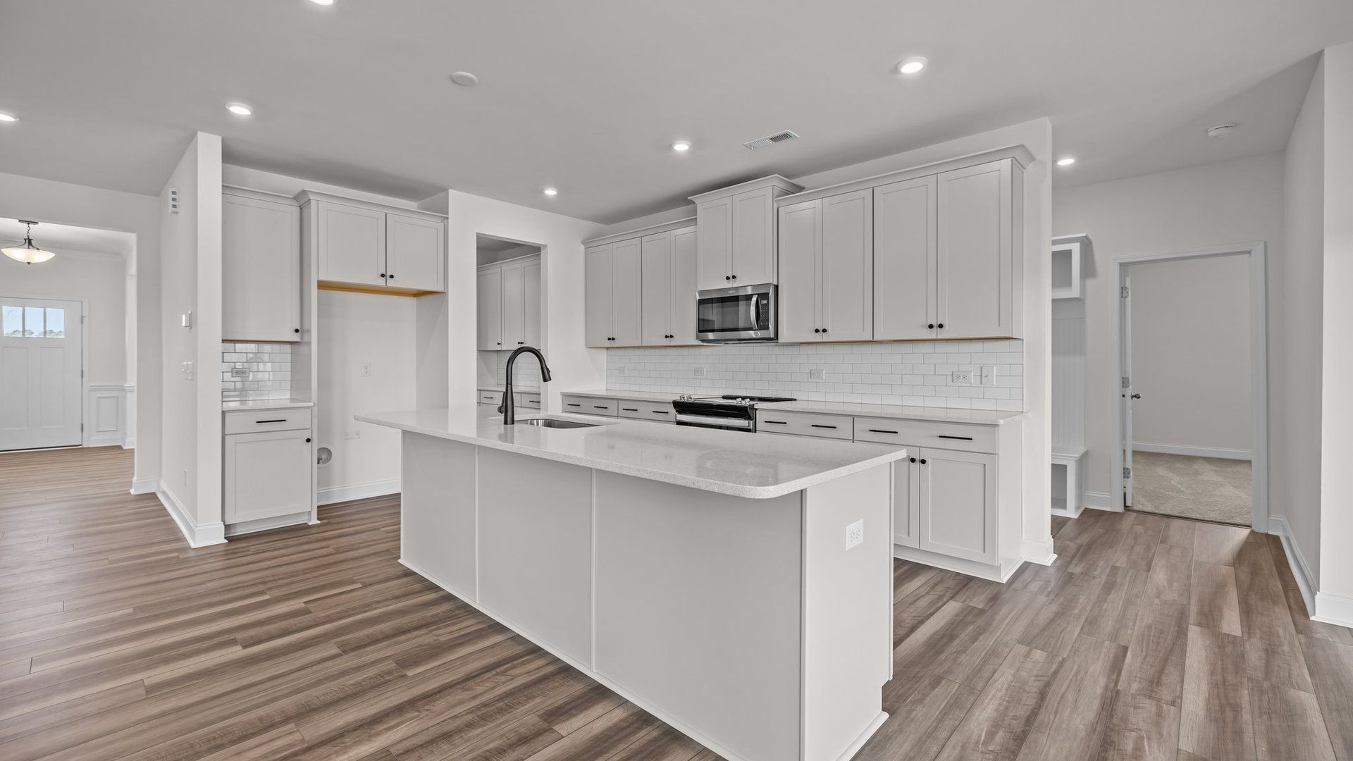Bright kitchen with large island and quartz counter tops, in the Norris Design by DRB Homes in York, SC